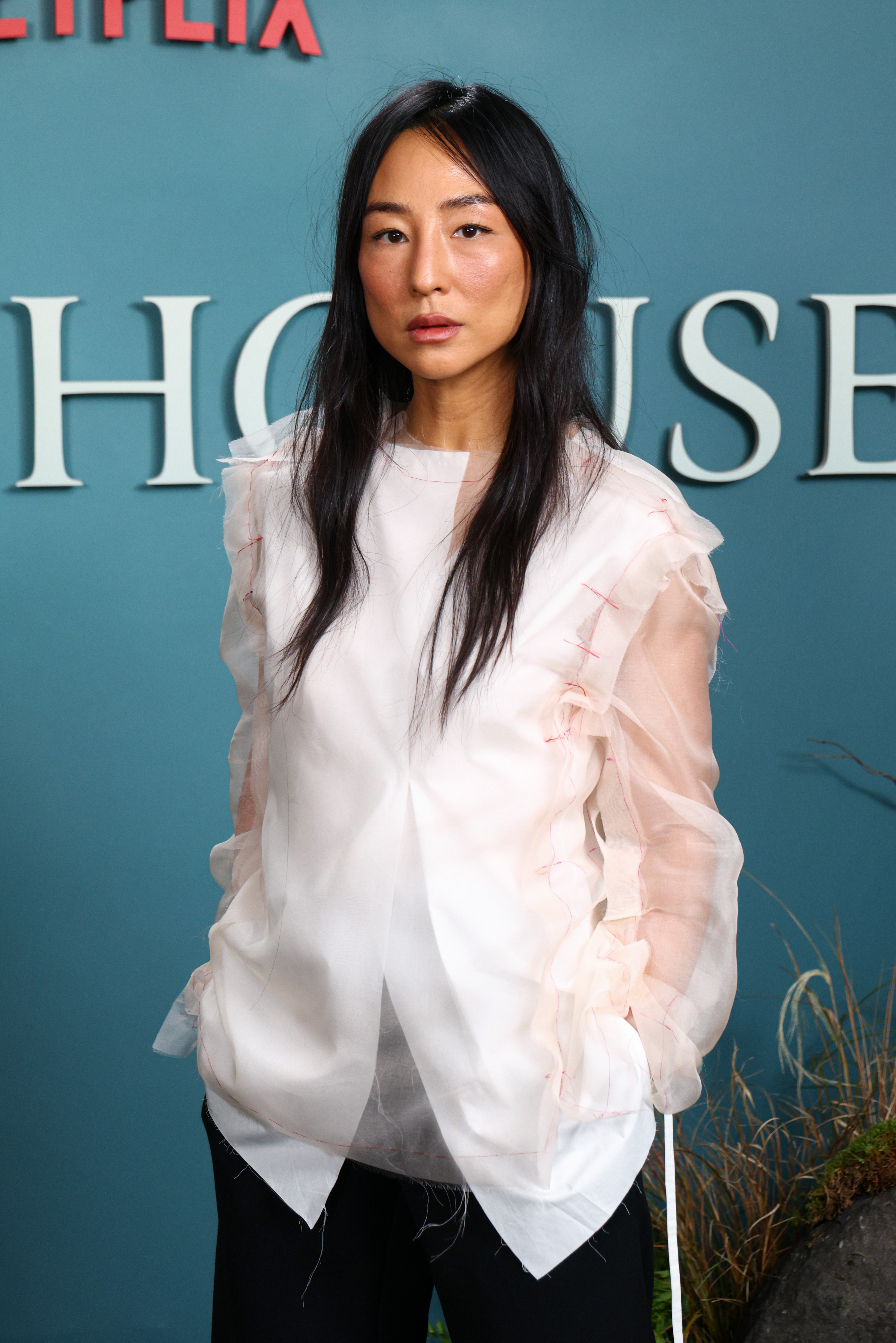 Greta Lee wears a white shirt by The Row