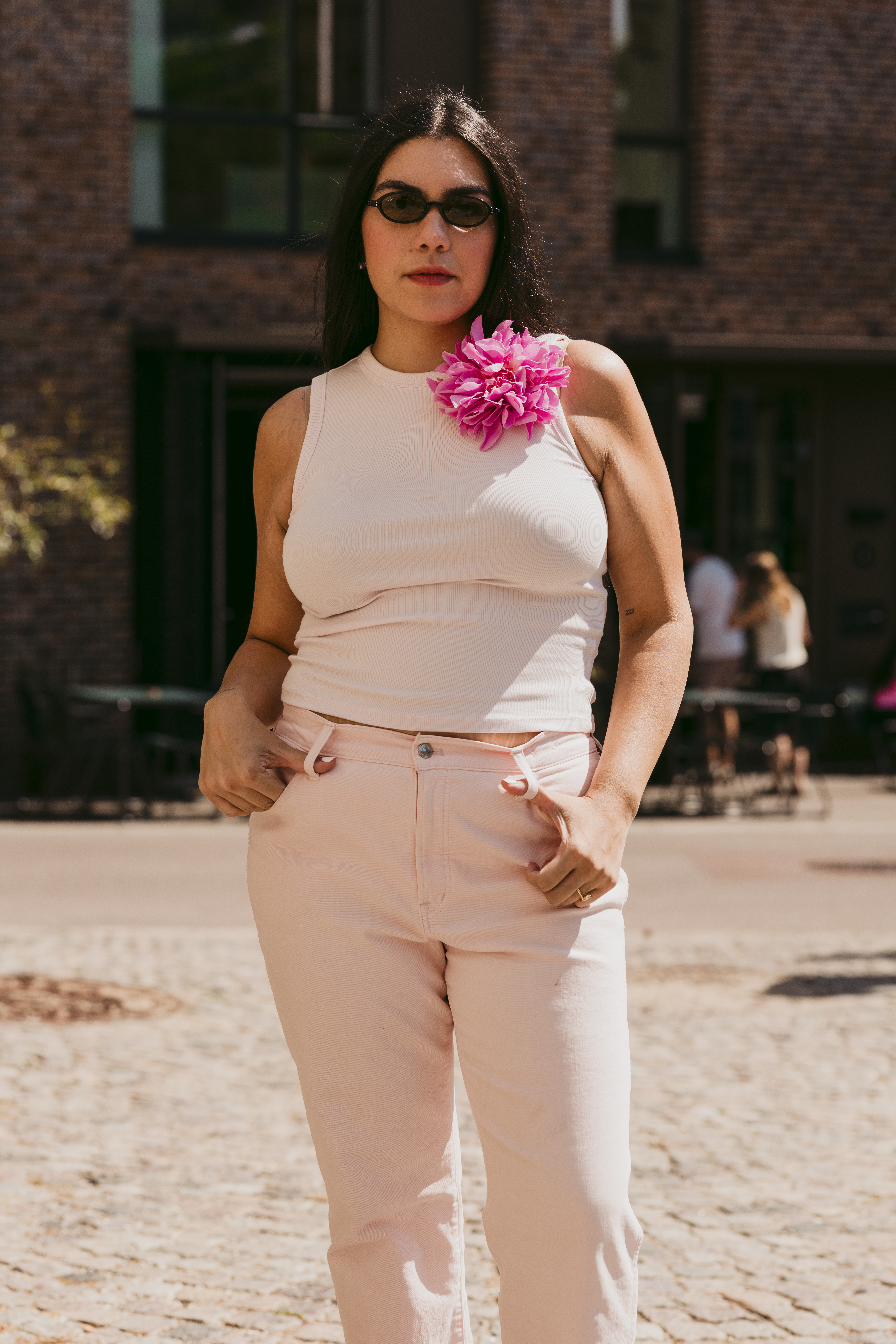 Copenhagen Fashion Week attendee wears an oversized feathery brooch with a tank top and jeans.