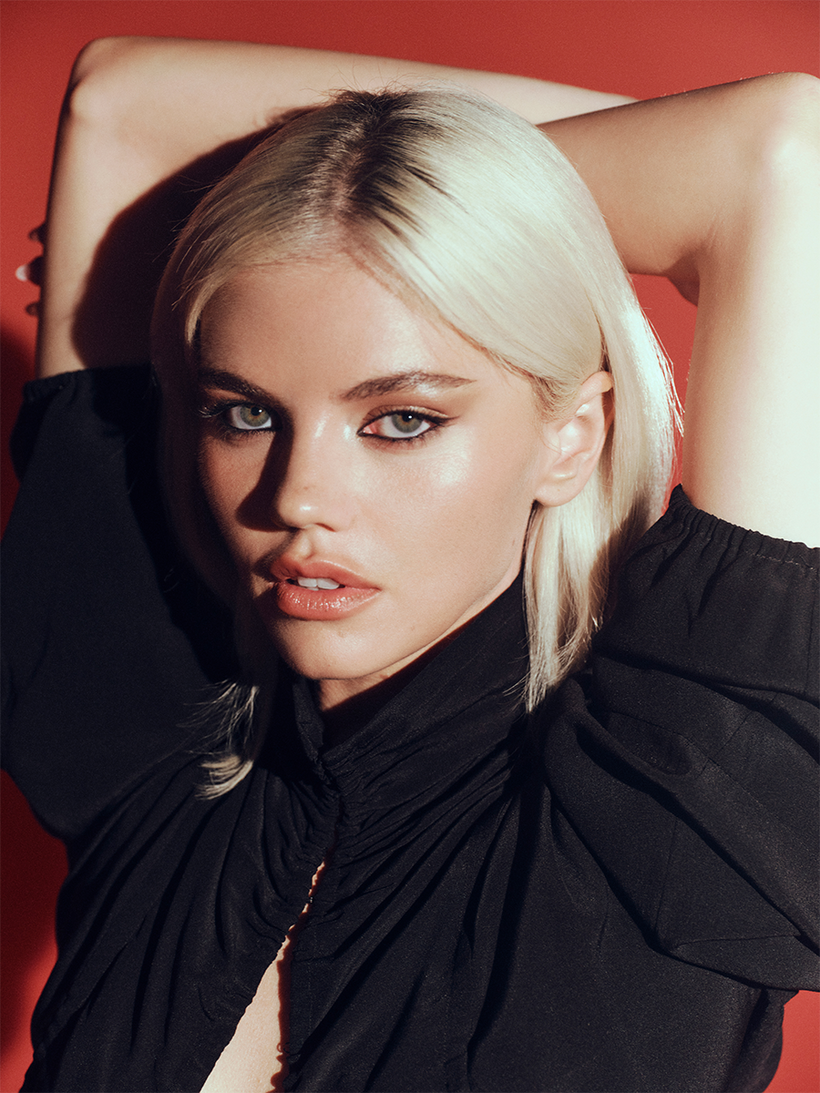 Hayes Warner photographed by Jonny Marlow. Her hair is platinum blonde, and she is wearing a black dress.