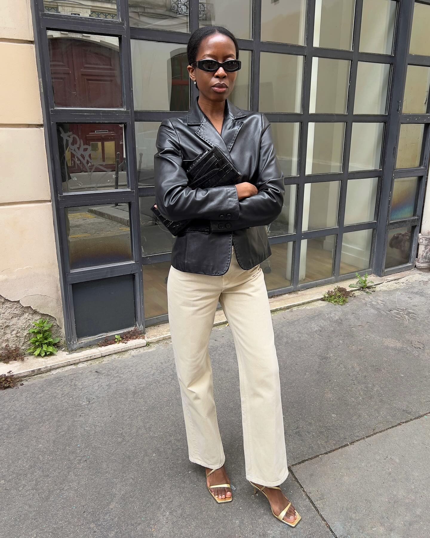 French woman wearing a leather blazer with tan jeans and sandals