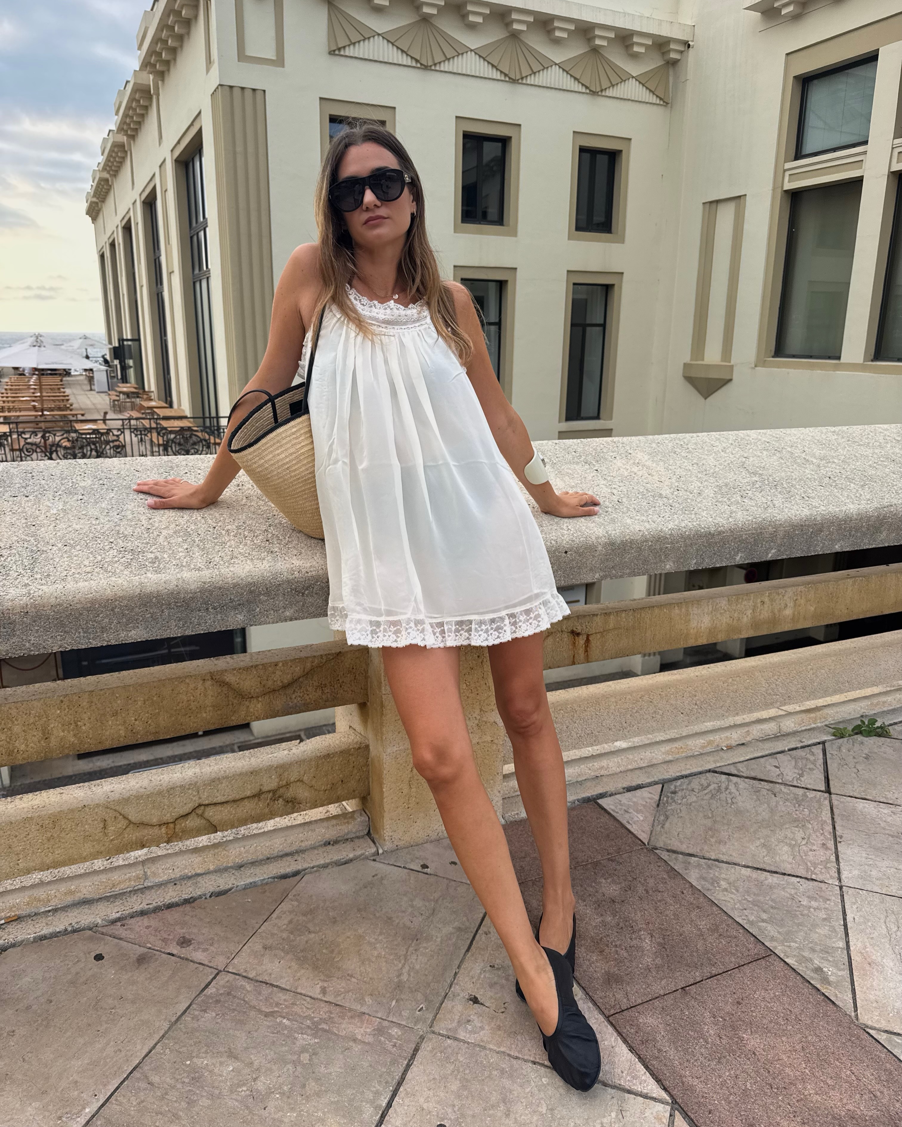 Woman in a white dress and ballet flats
