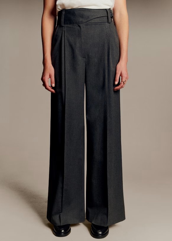 A model wearing grey tailored Sezane trousers.