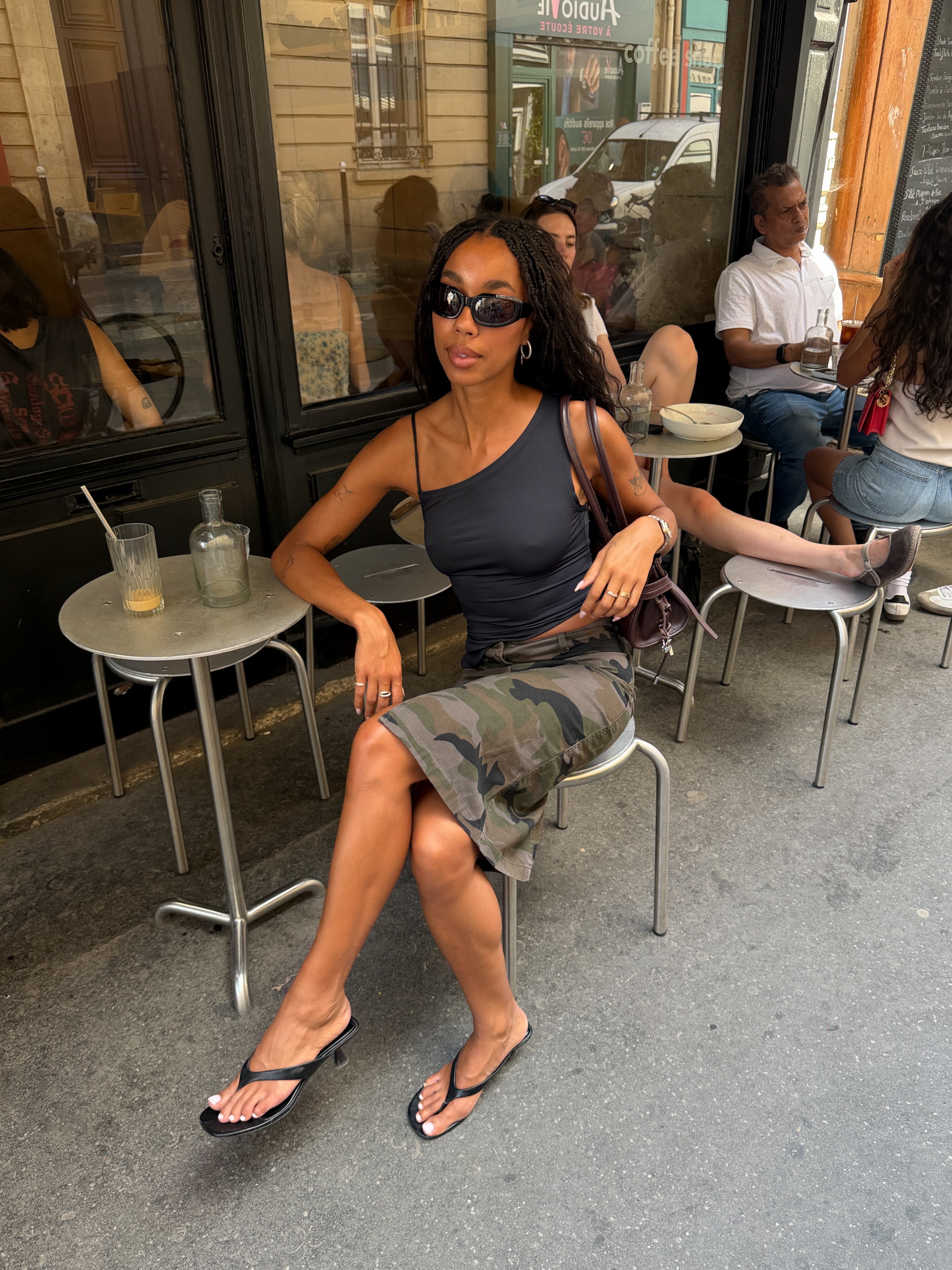 An image of @amaka.hamelijnck  wearing long cargo shorts with heeled flip-flops and an asymmetrical top.
