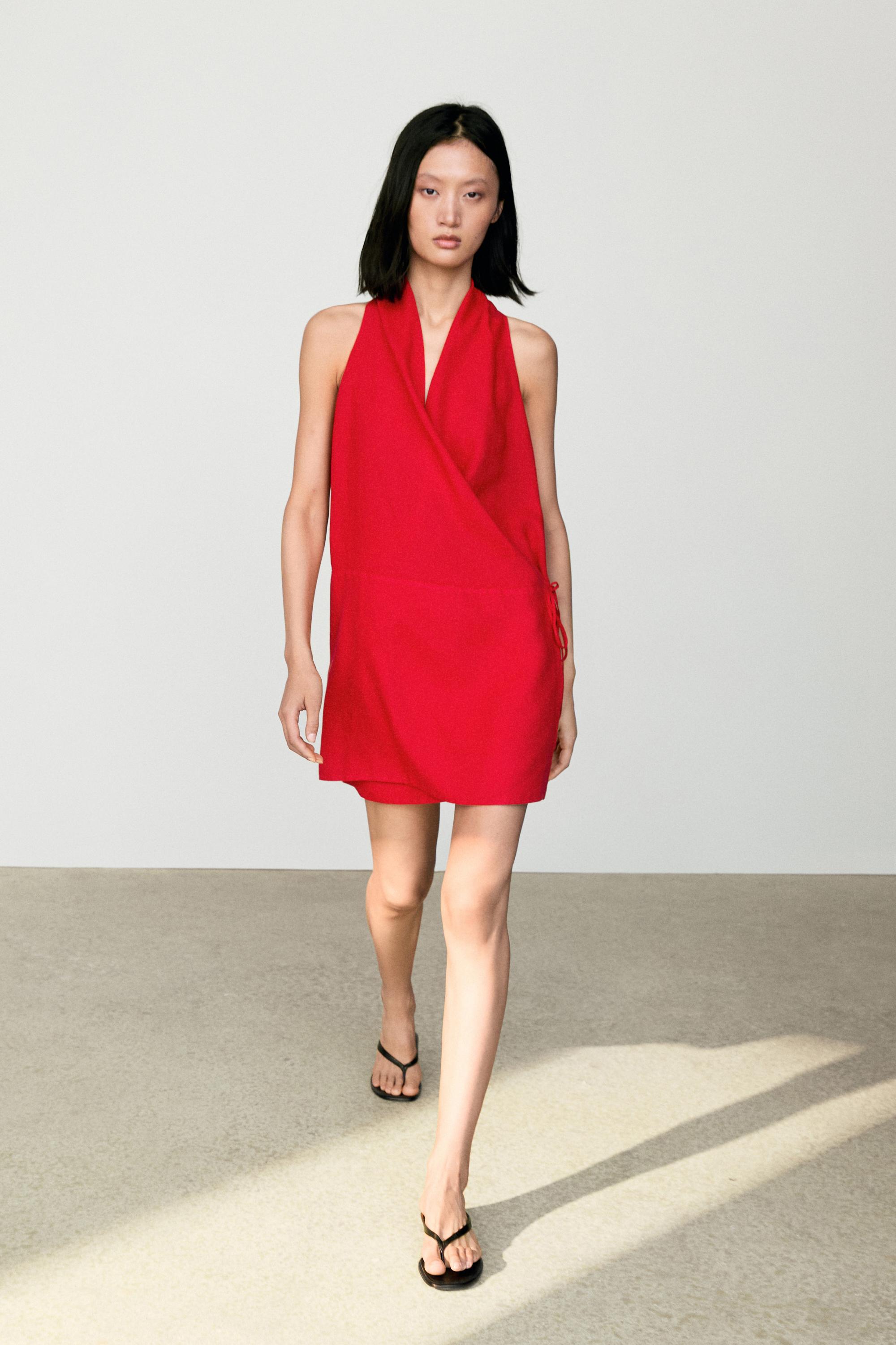 An image of a model in a red linen wrap mini dress