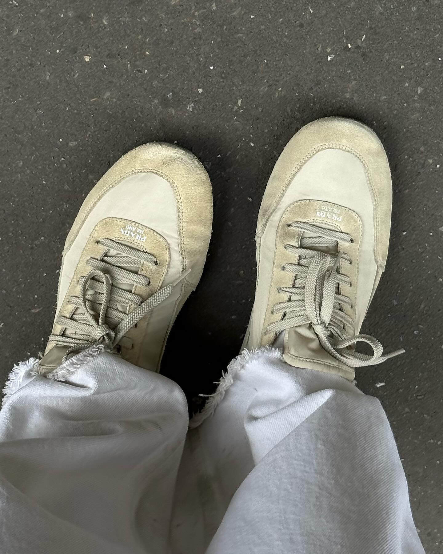 An image of @alisontoby wearing white jeans with suede tim beige trainers from Prada.