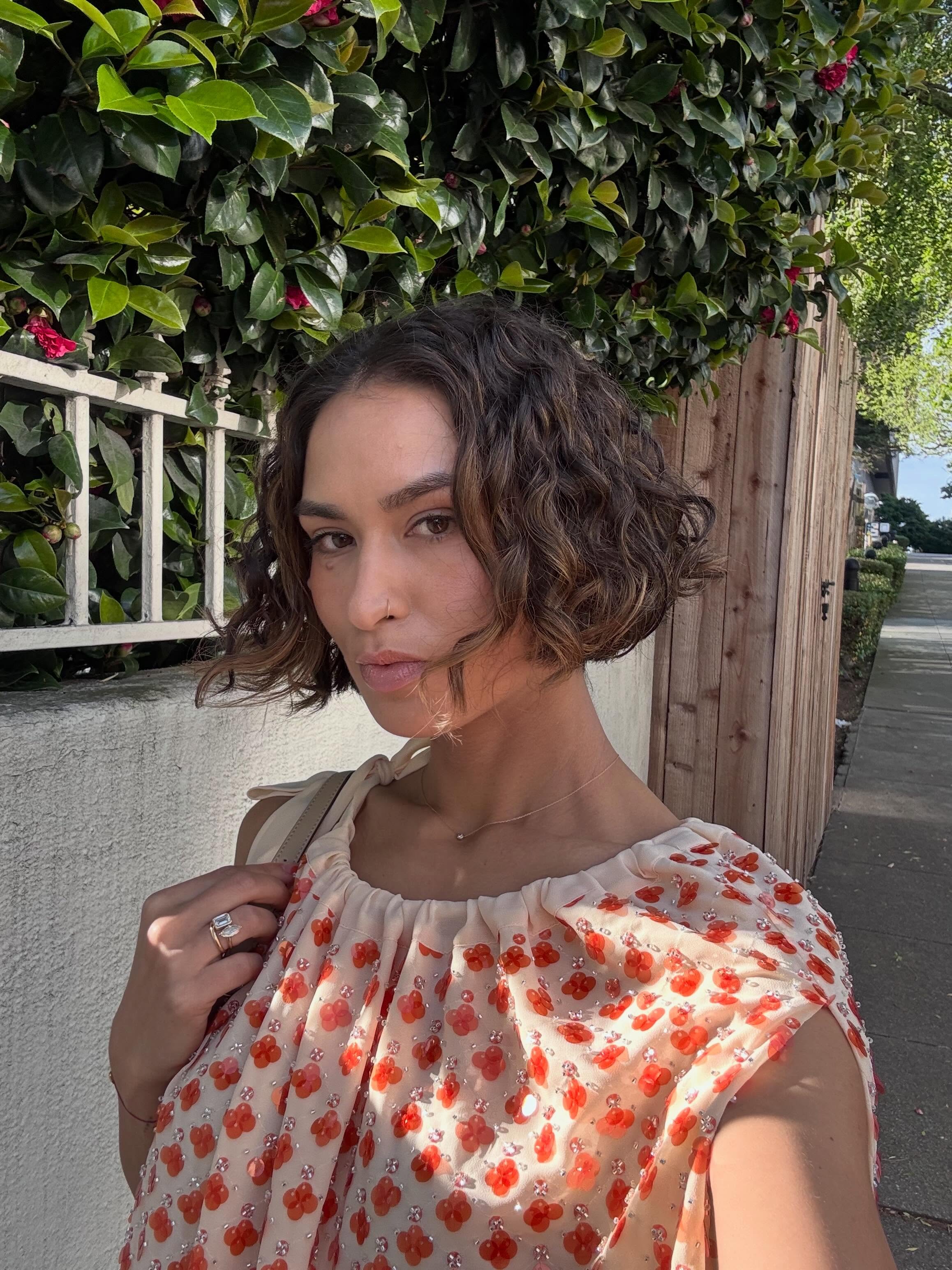 A woman with a curly bob and fine highlights.