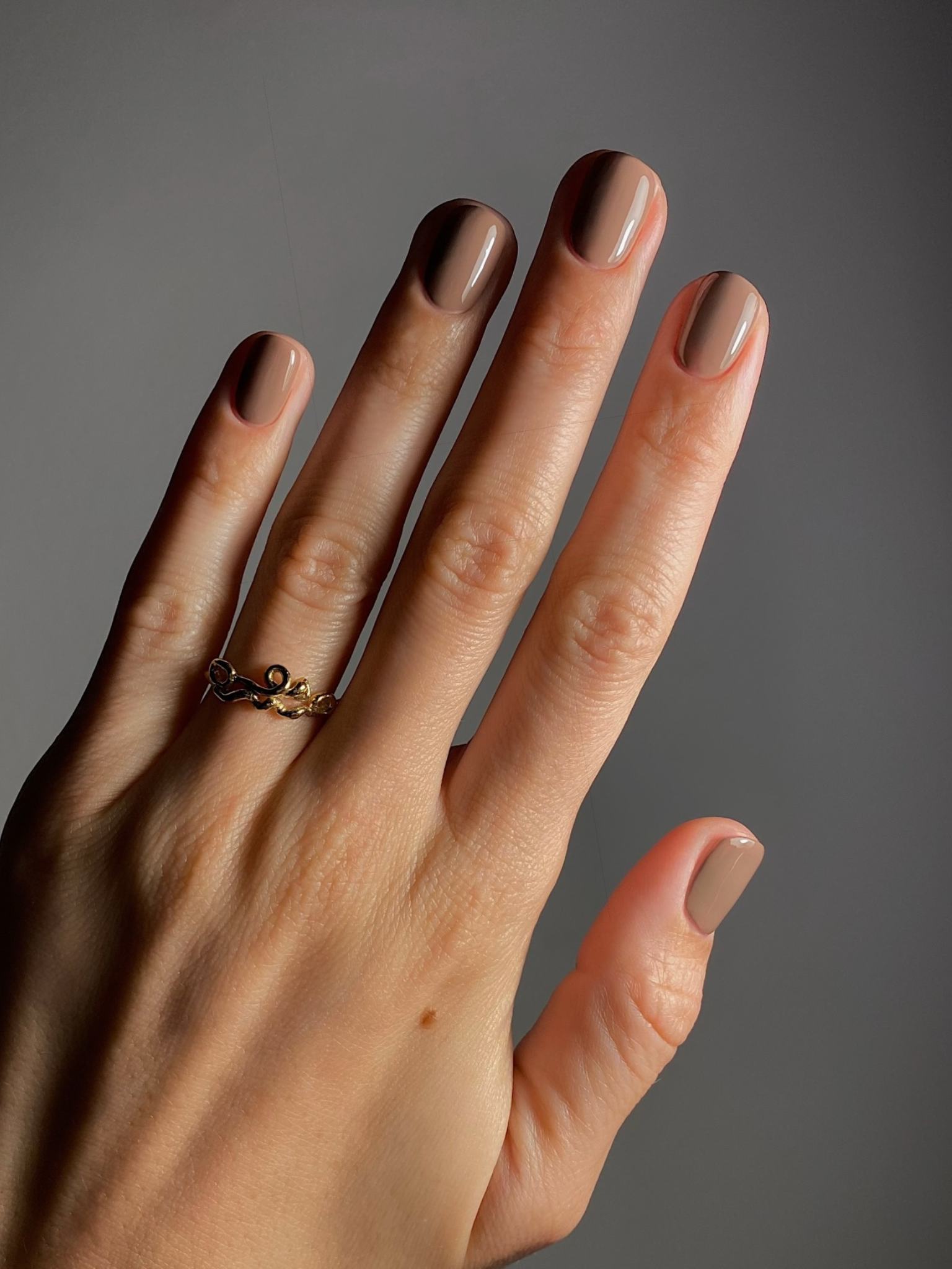 A sandy brown colour on short nails.