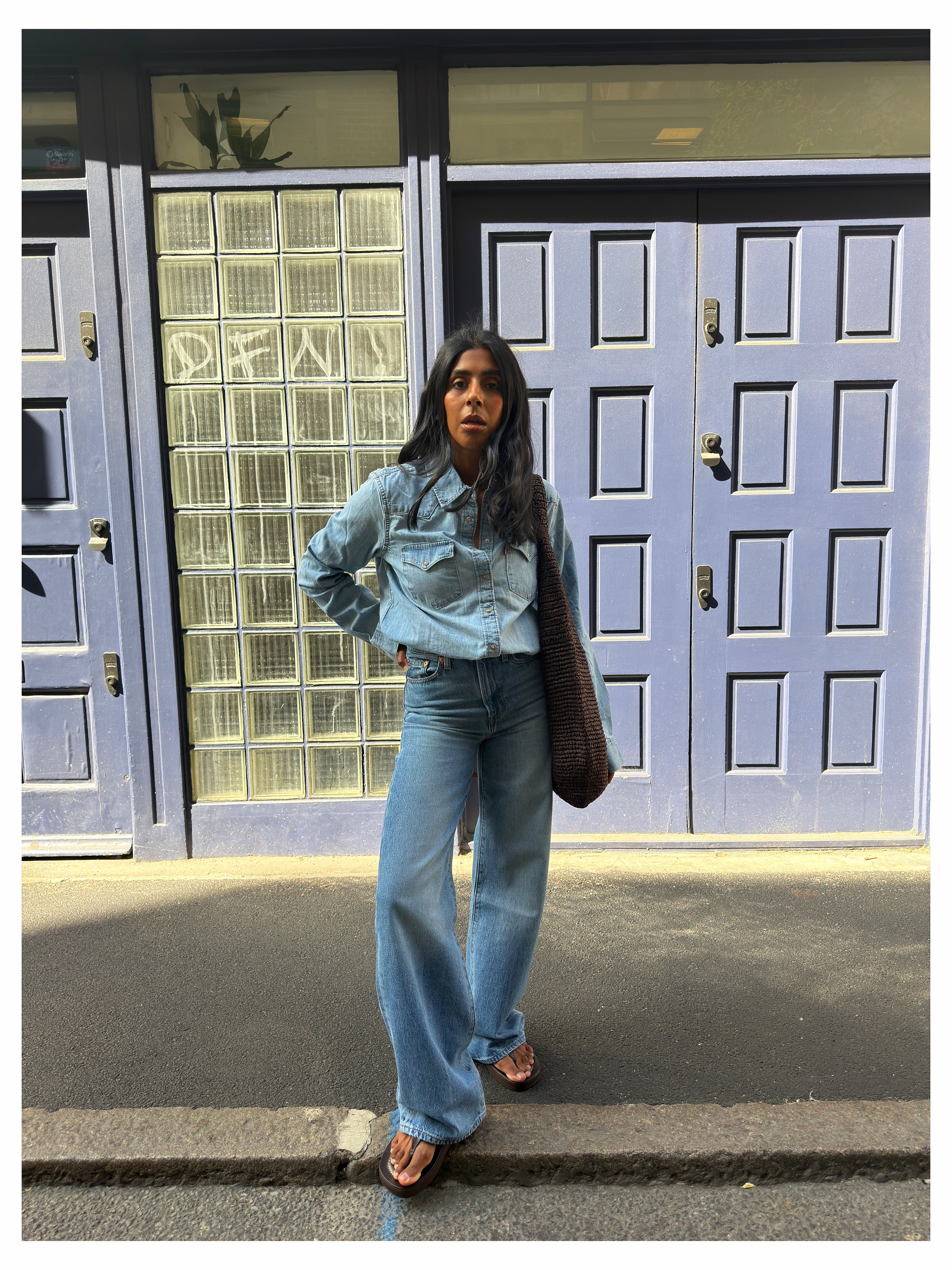 Influencer Monikh wearing a denim shirt, dtraight leg jeans and thong sandals.