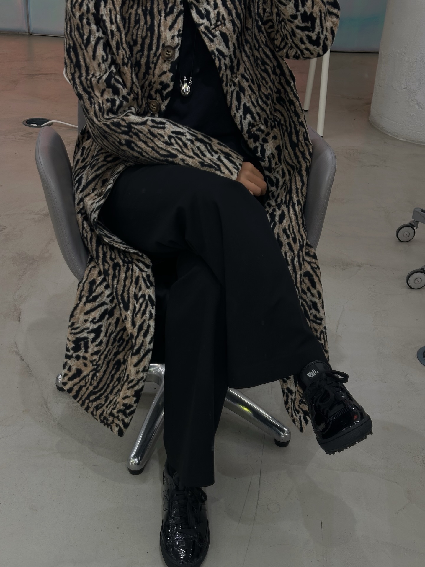 An image of @deborabrosa wearing bubble sole trainers from New Balance with a leopard-print coat.