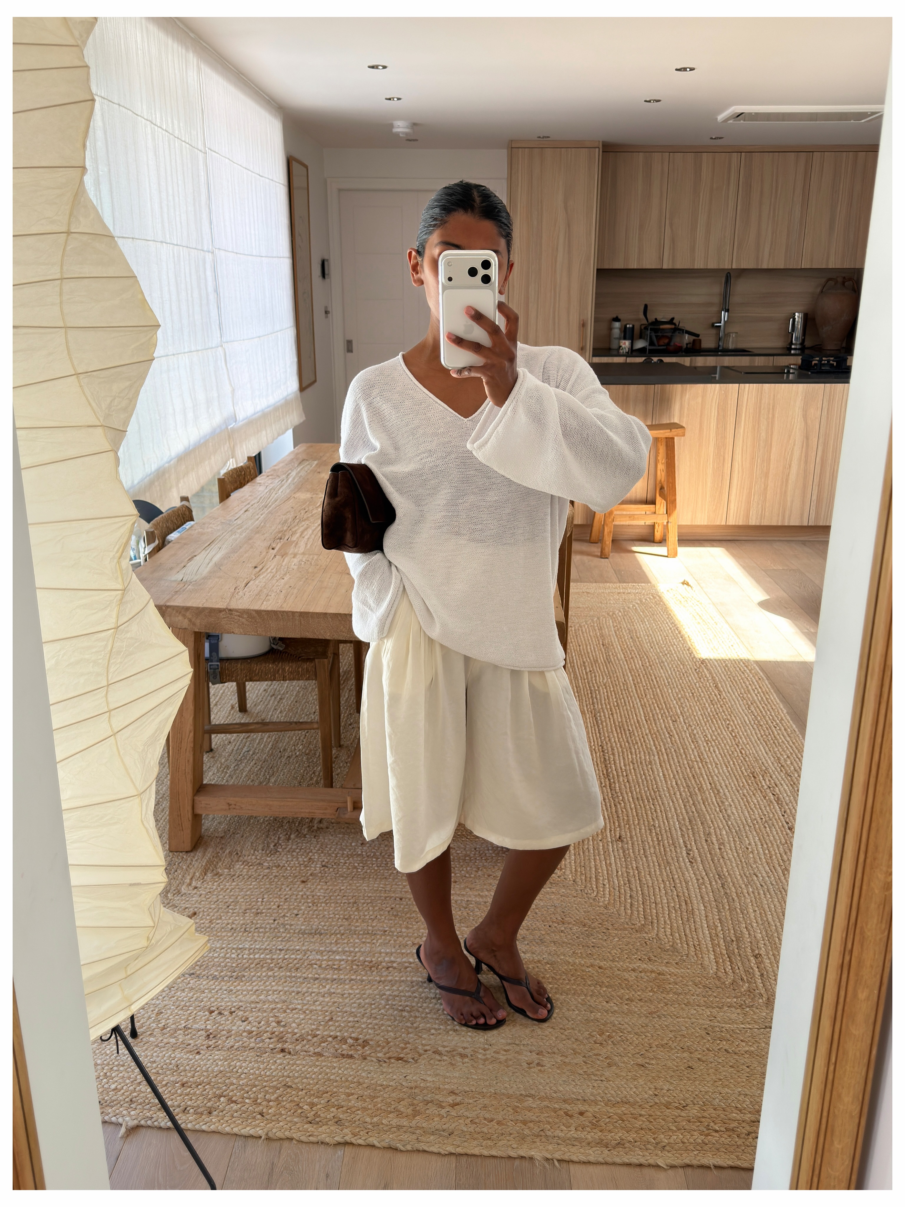 Influencer Monikh wearing cream longline shorts and a white long sleeve t-shirt.