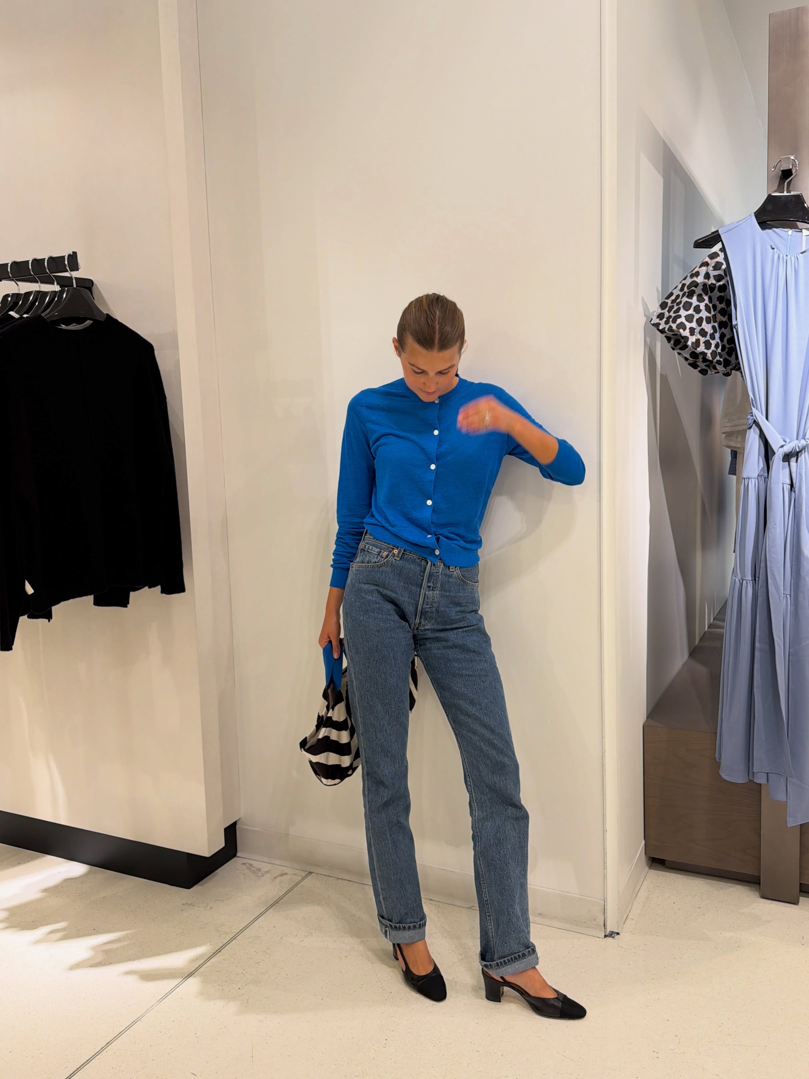 Influencer Sara Walker wearing a thin blue cardigan, slim leg jeans and slingback heels.