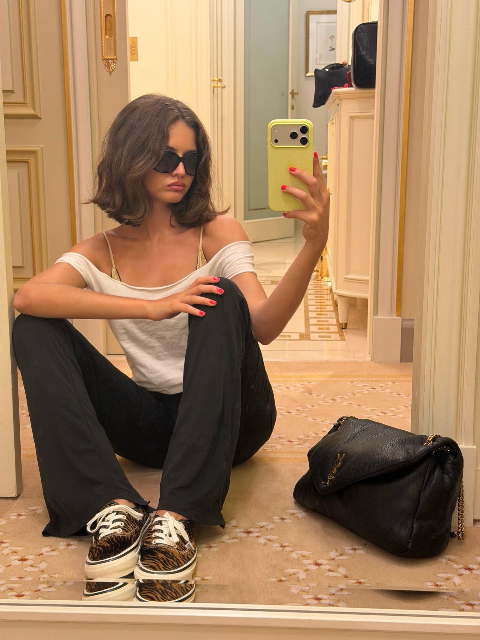 An image of @rubylyn_  wearing a white shirt with black trousers and tiger print trainers from Vans.