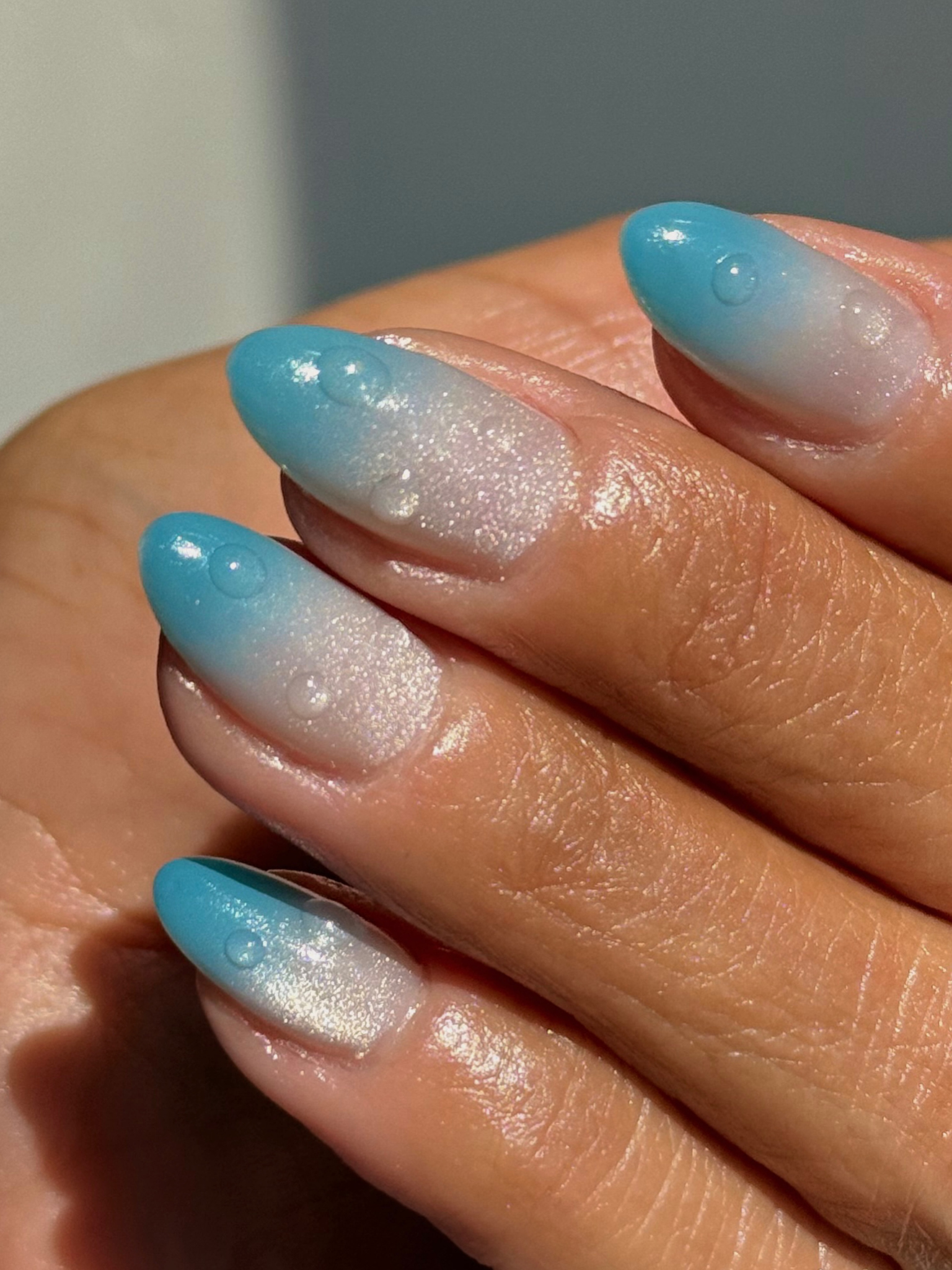 An ombre effect fading from sea blue to silver shimmer.