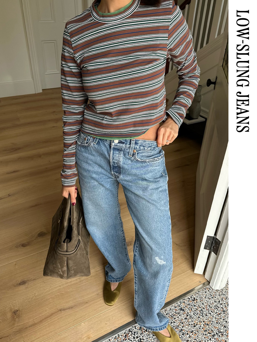 Woman wearing a striped long-sleeve T-shirt, jeans, and satin flats