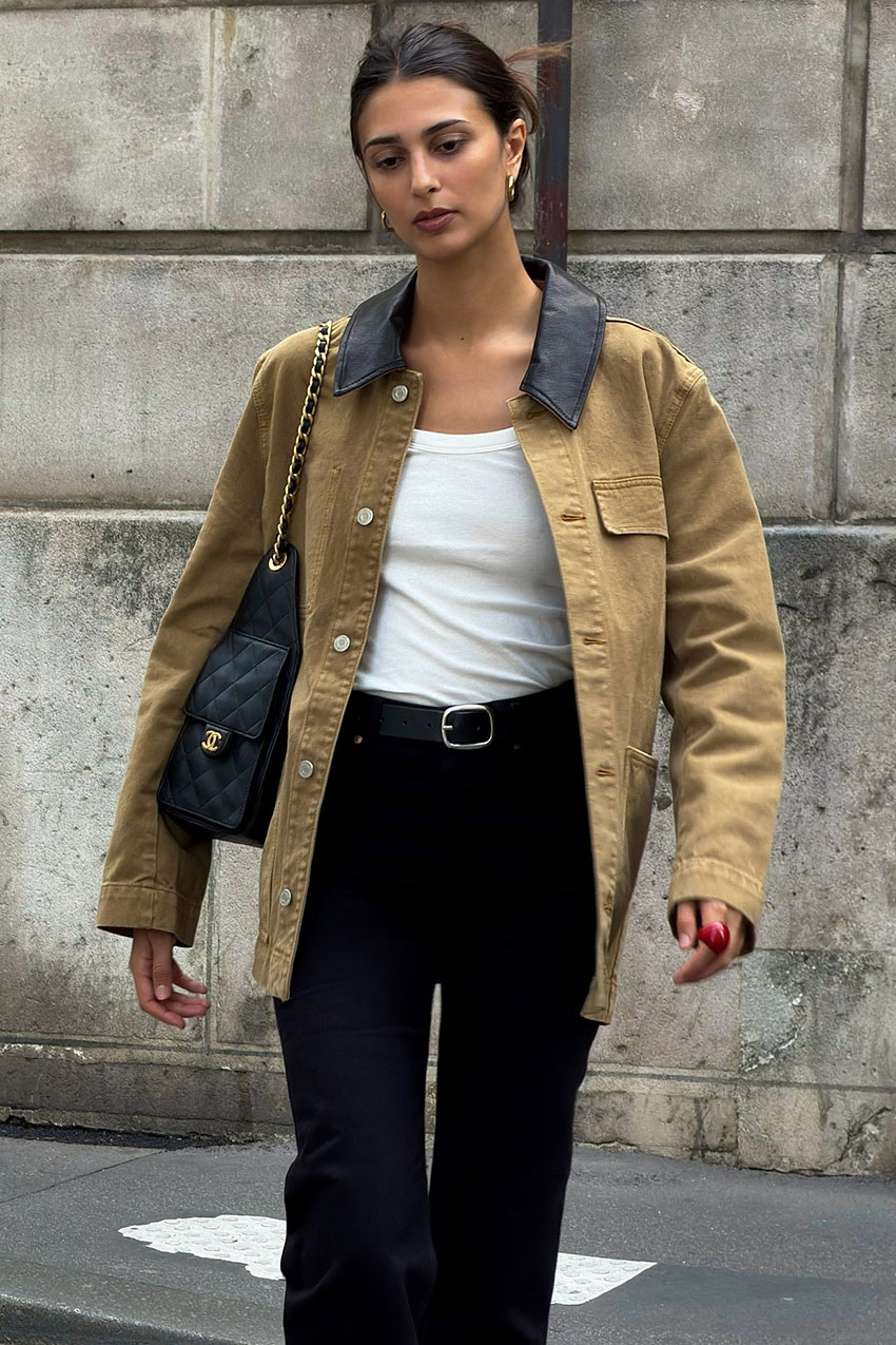 a woman wearing a contrast collar jacket, white tank top, and black pants