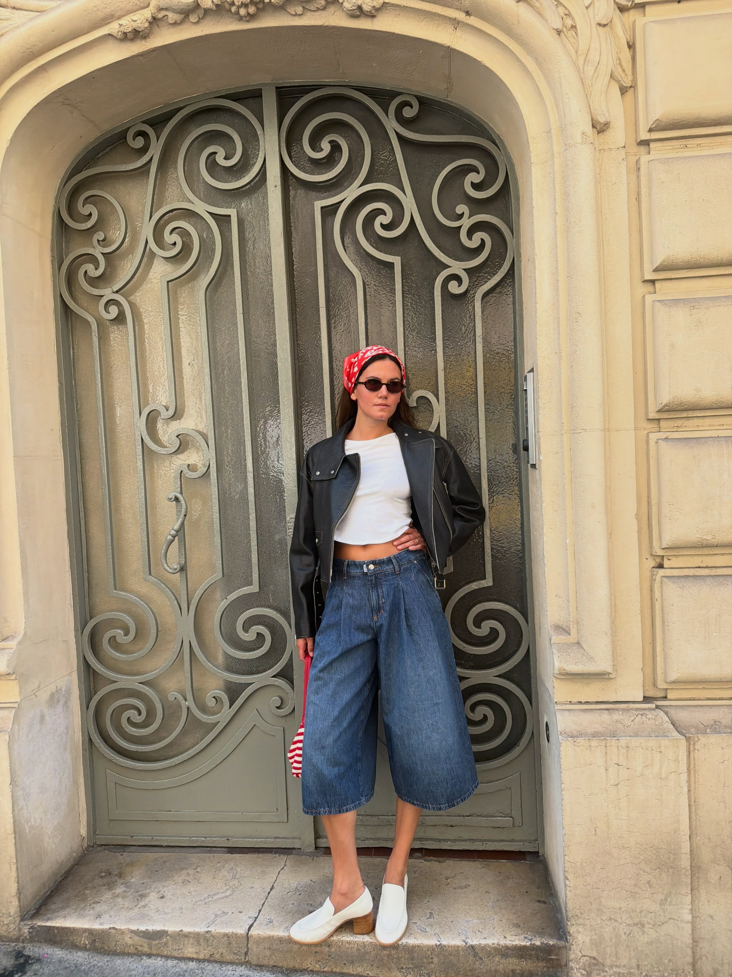 A woman wearing long, loose denim shorts in summer 2026.