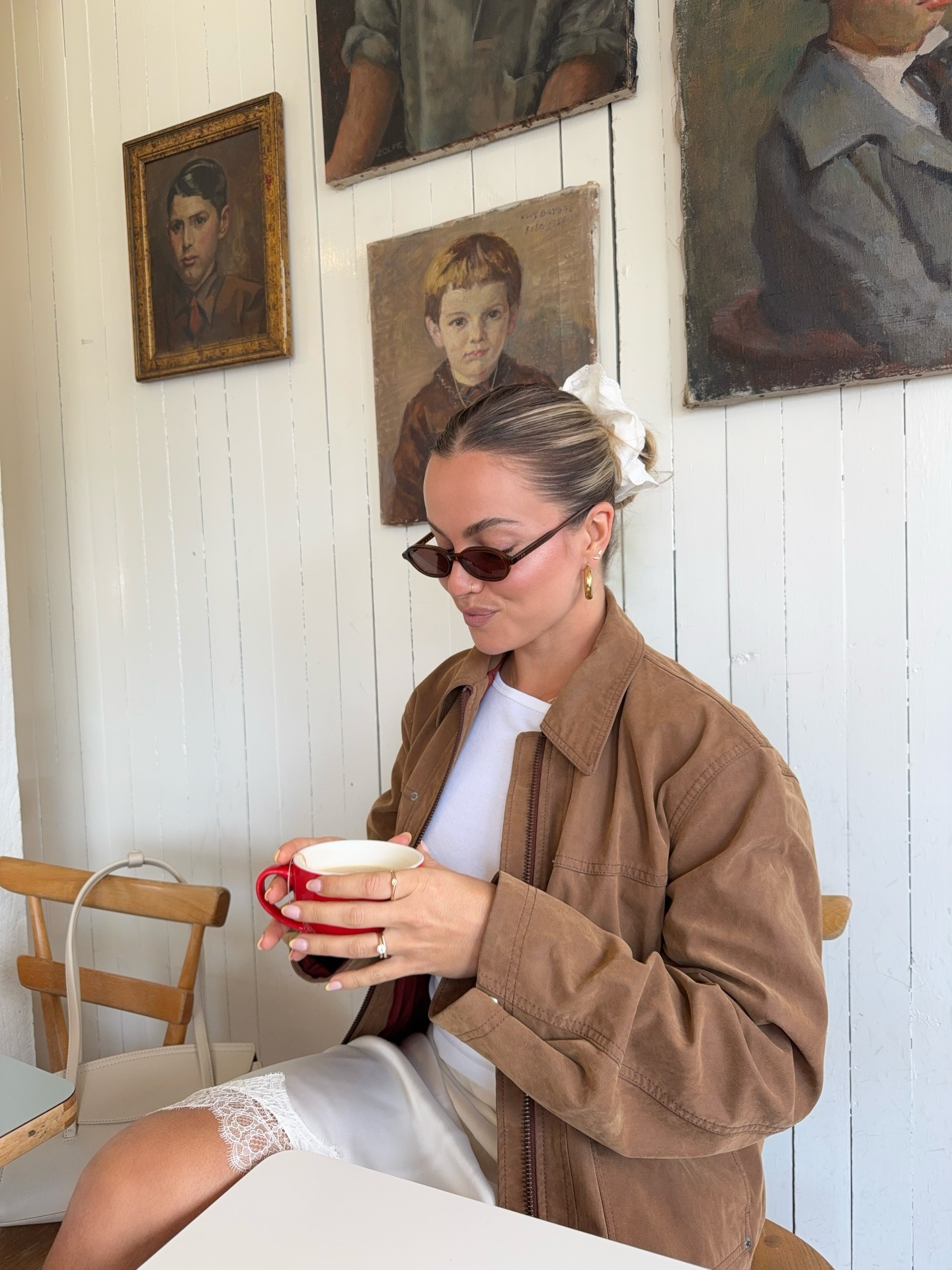 @izzydilg in a lace trim skirt, suede jacket, and white shirt.