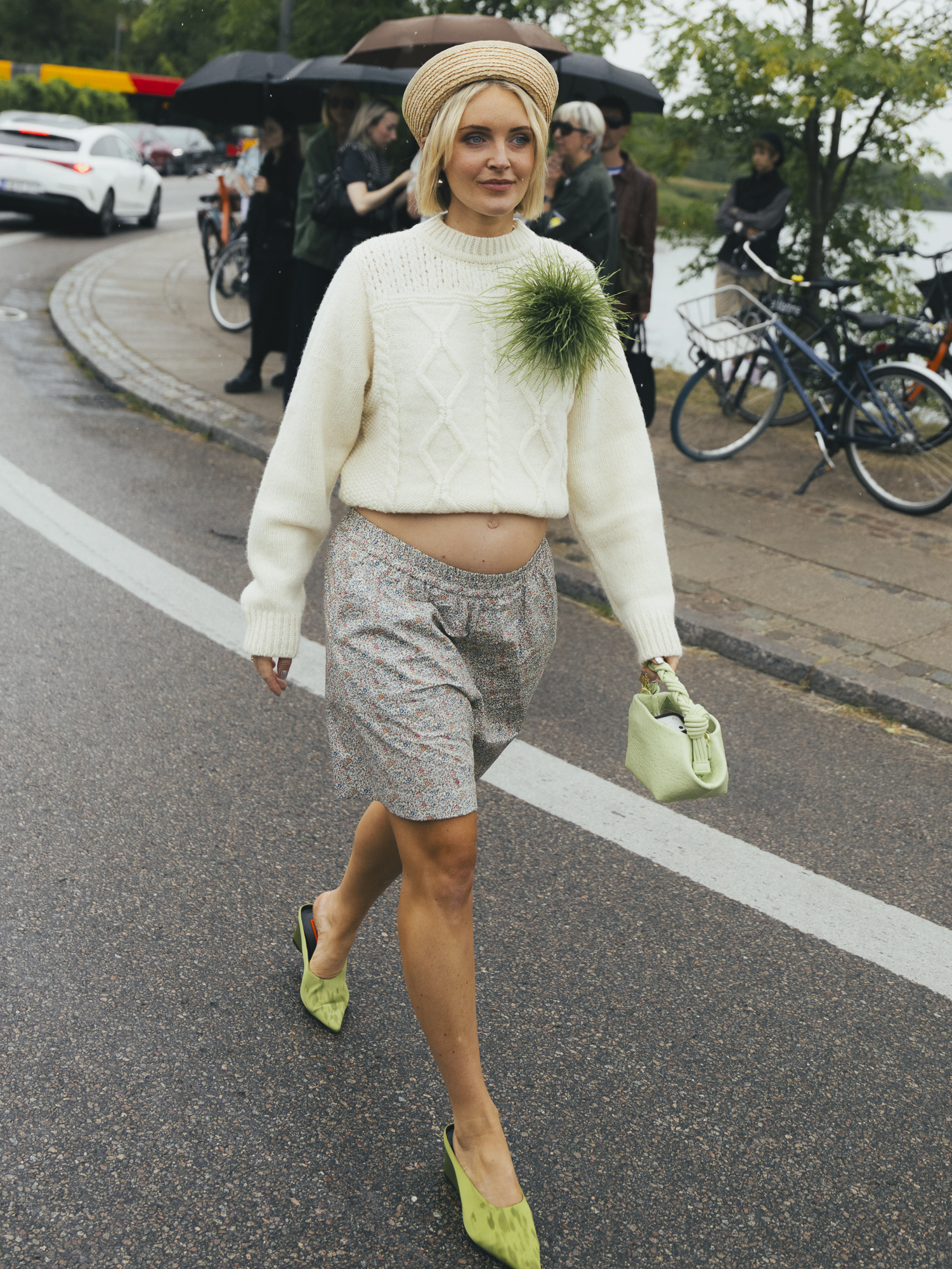 Copenhagen Fashion Week attendee wears an oversized feathery brooch with a jumper and shorts.