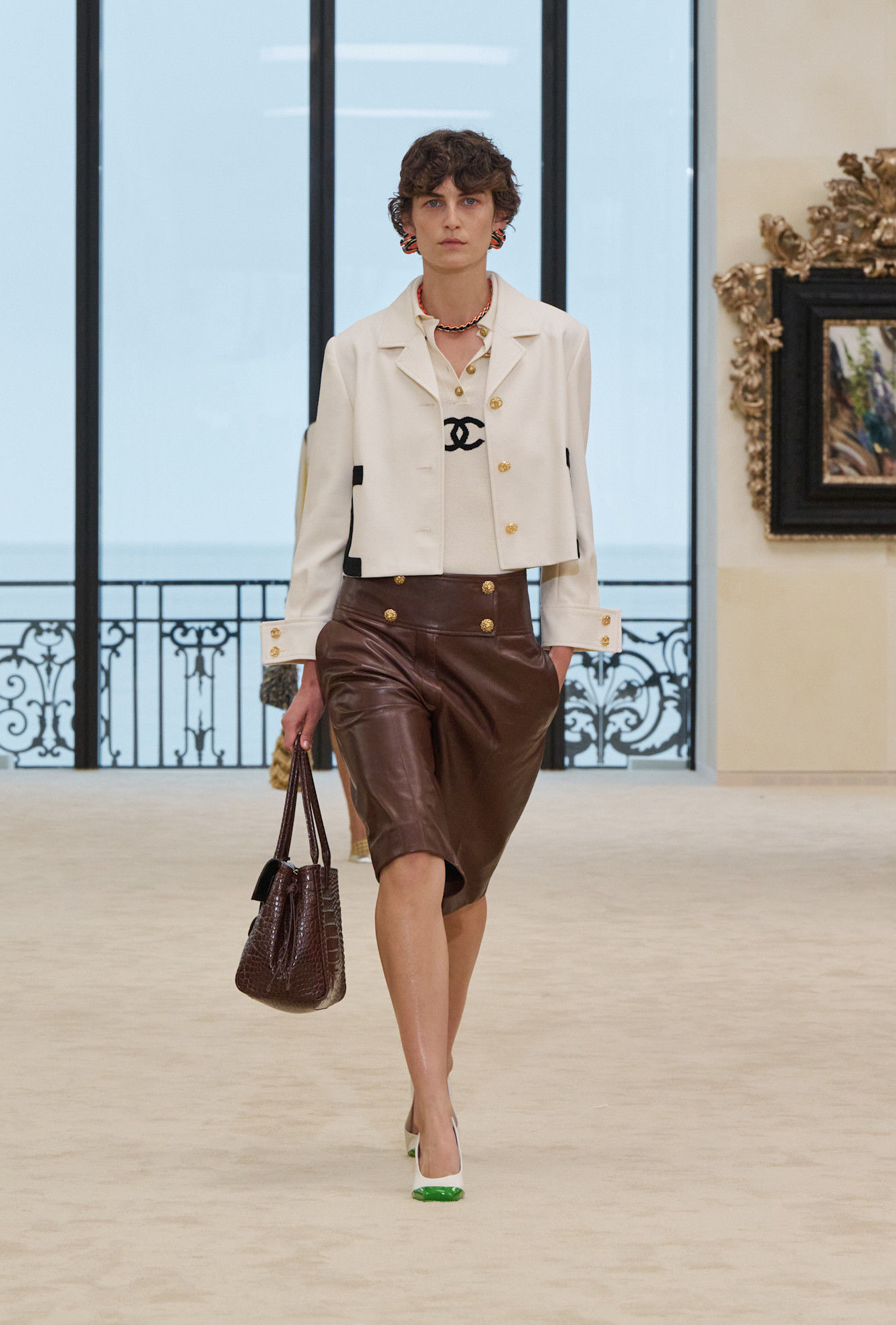 An image of a model on the Chanel Cruise 2027 runway wearing long shorts.