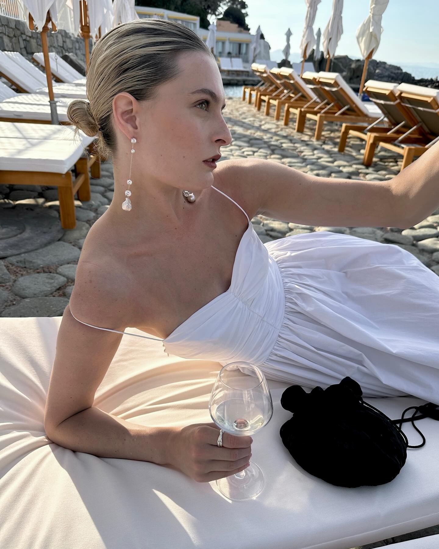 Woman wearing black evening pouch bag.