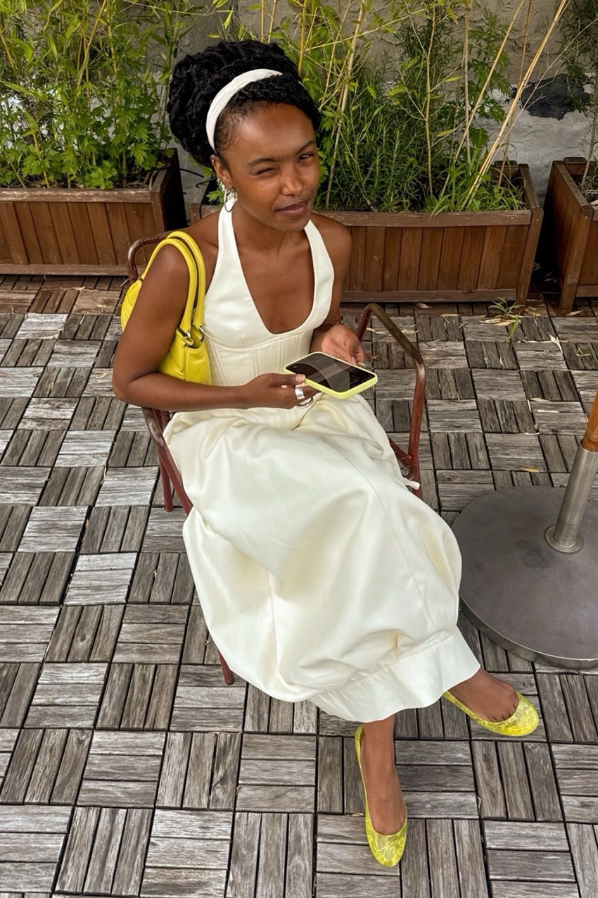 a woman wearing a white dress and neon yellow satin flats