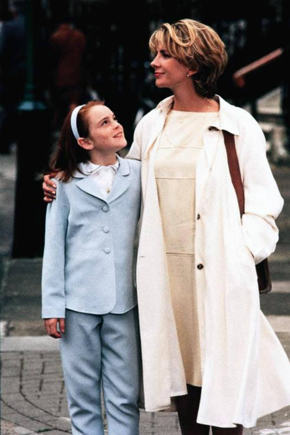 Elizabeth James wears cream dress and trench coat