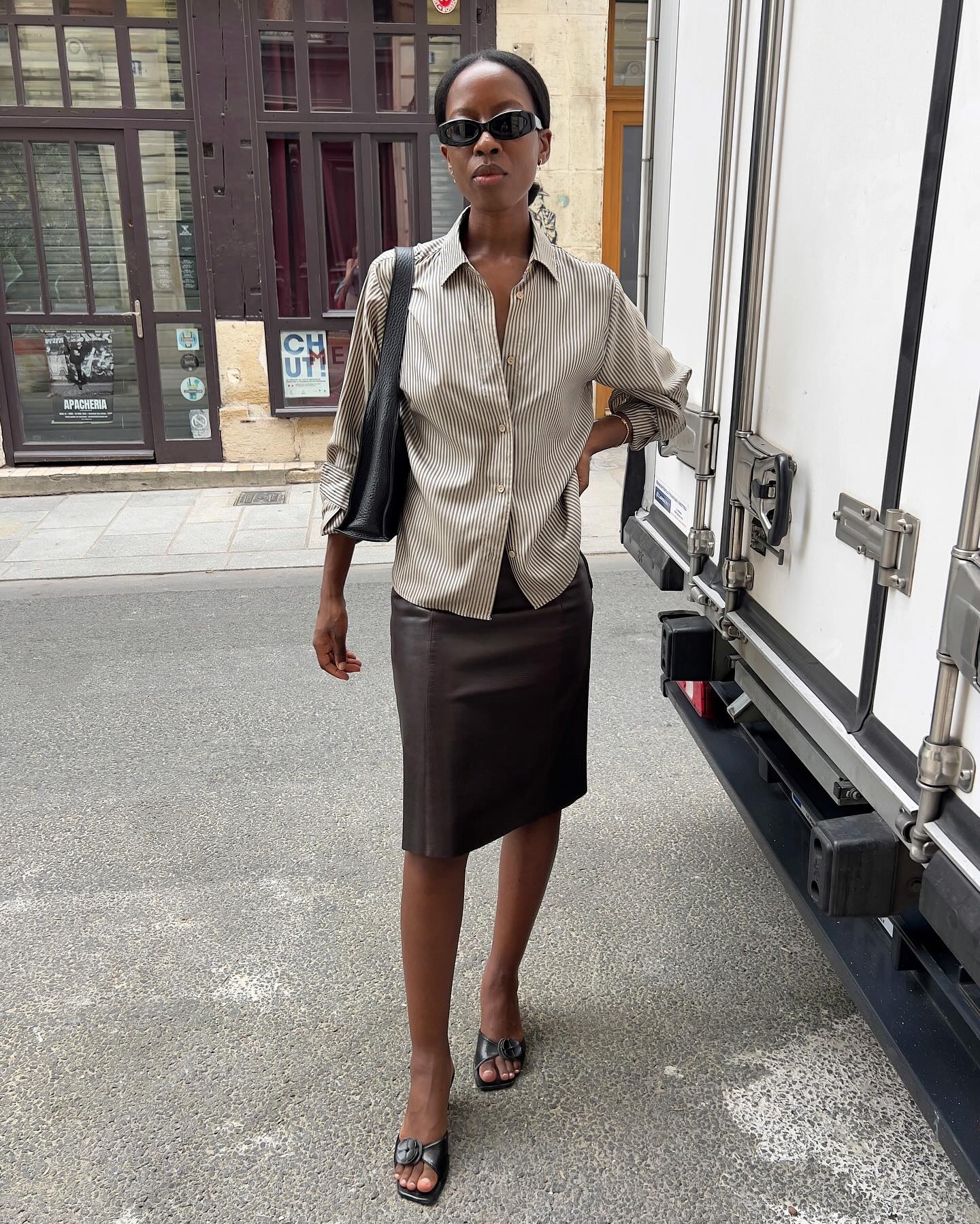sylvie mus wears a striped shirt, pencil skirt and mules
