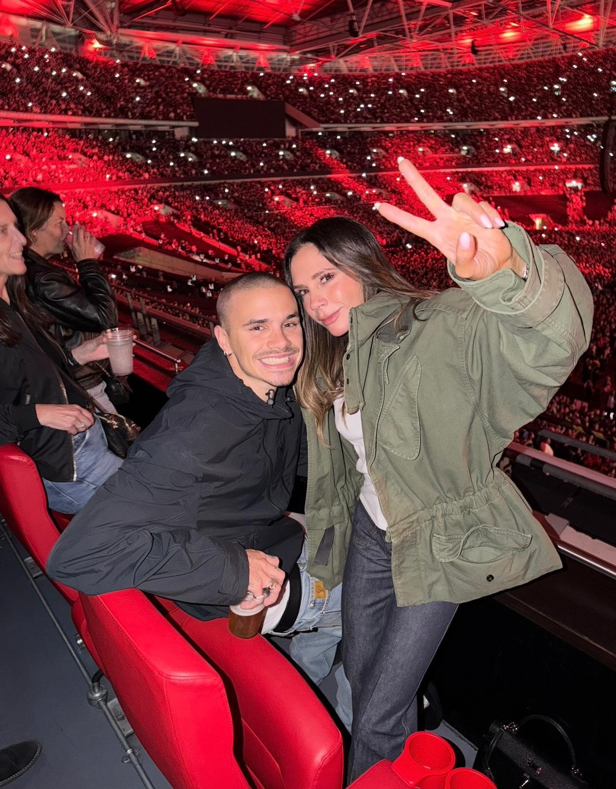 Victoria Beckham wears a khaki drawstring jacket with a white t-shirt and jeans.