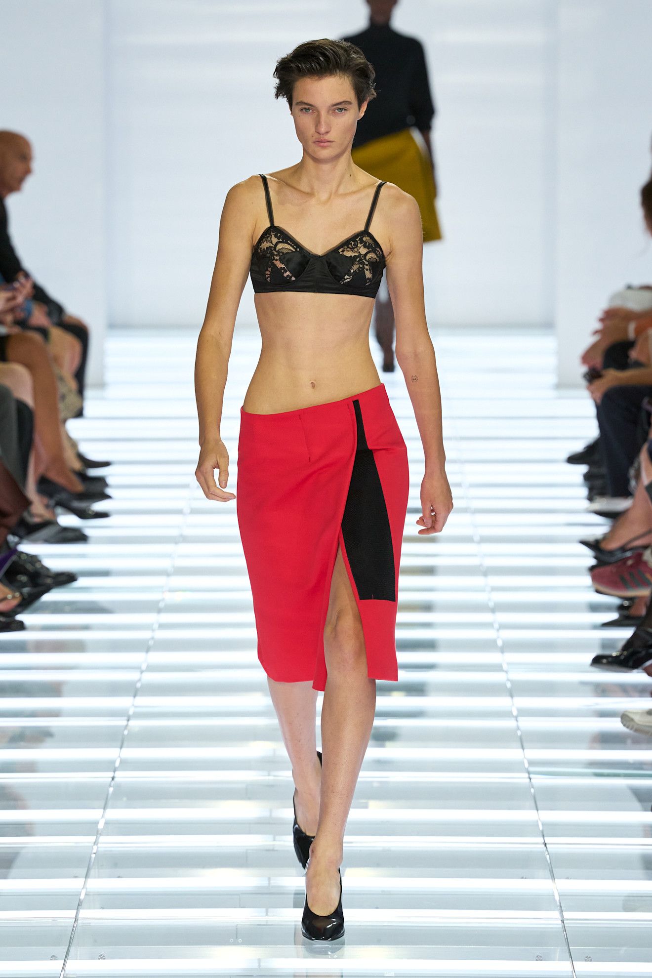A model walking in a bralette and skirt at the S/S 27 Milan Fashion Week Prada show.