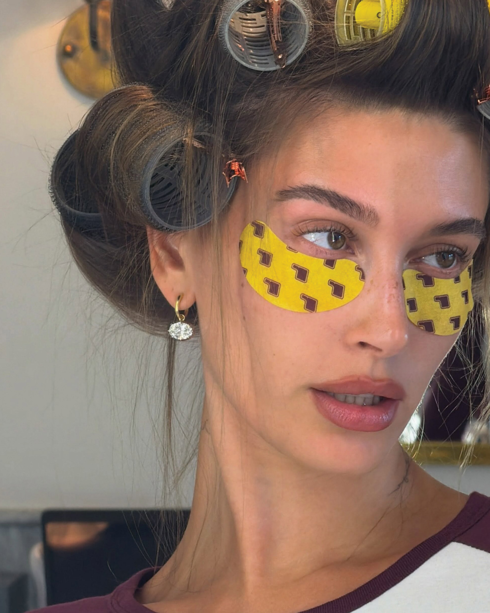Hailey Bieber wearing Rhode eyemasks and oval-shaped diamond drop earrings.