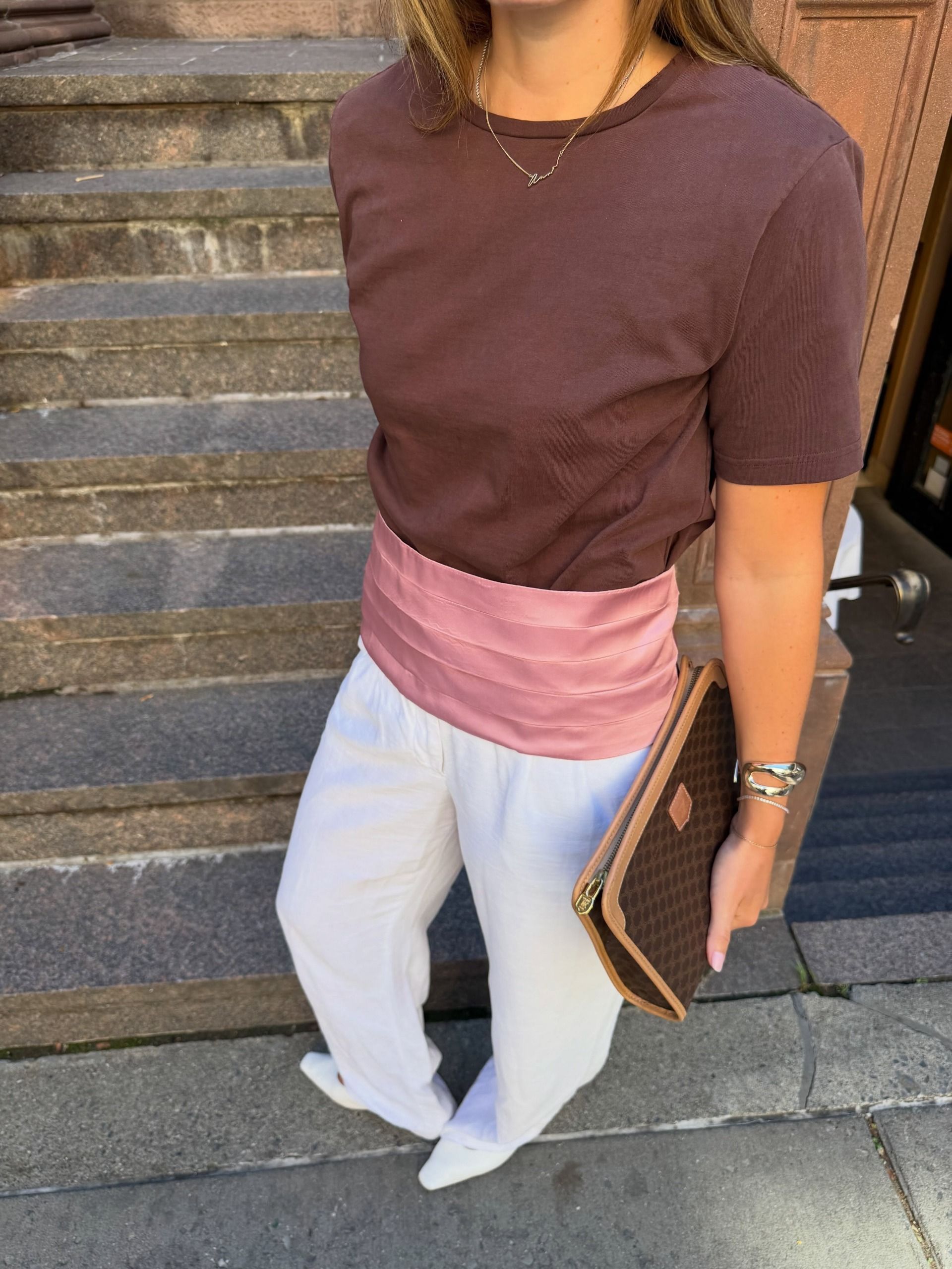 fashion editor wearing a T-shirt with white pants and shoes and pink Zara cummerbund belt