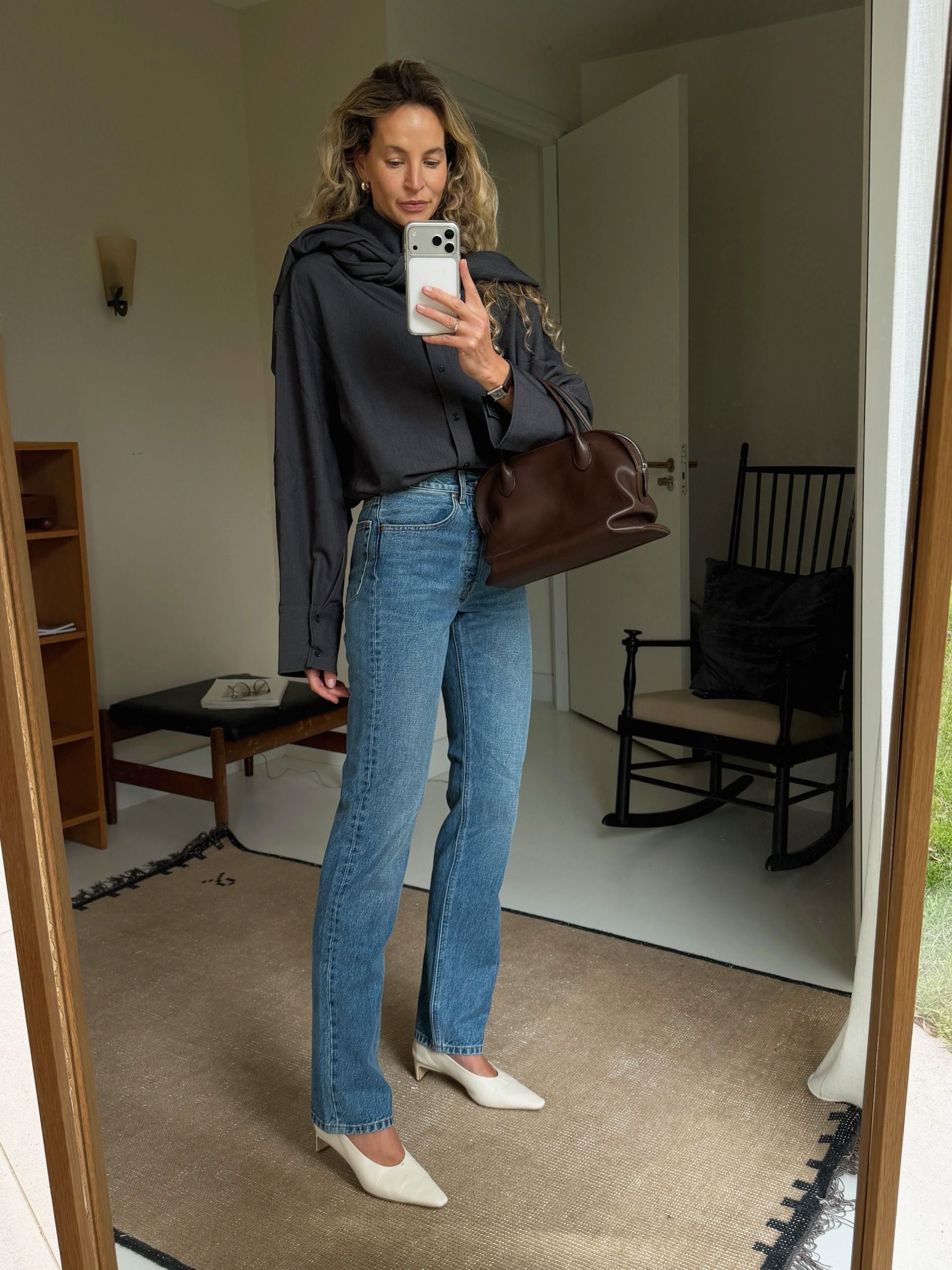 fashion influencer wearing a button-down shirt and matching scarf, jeans, and white kitten-heel pumps