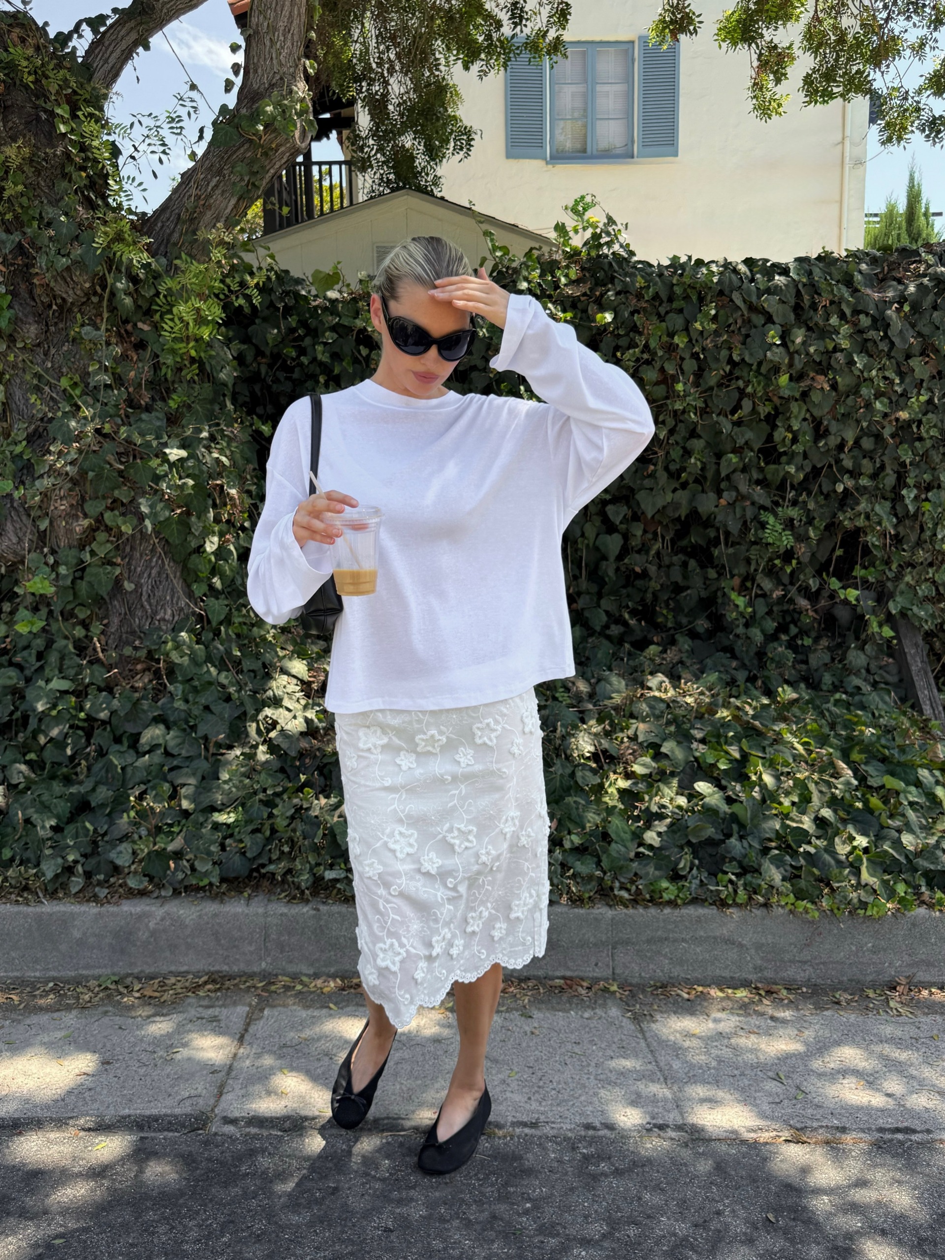 Woman in a white tee and midi skirt.