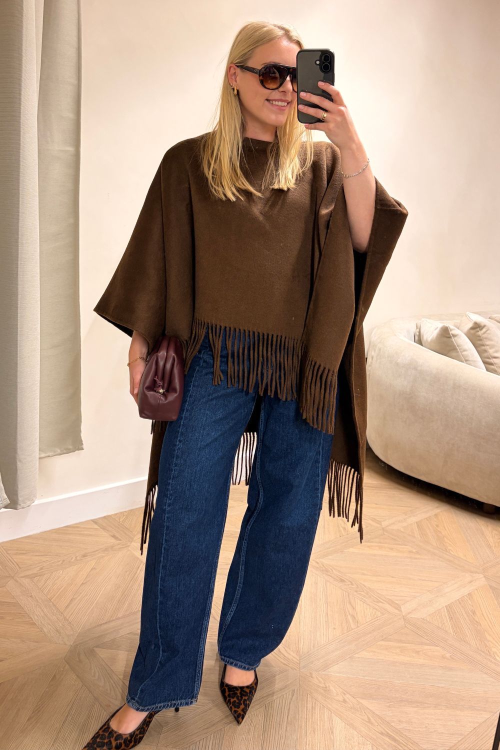 Shopping editor, Florrie, wears a brown fringe poncho, blue barrel-leg jeans, leopard print heels and burgundy clutch all from Marks & Spencer.