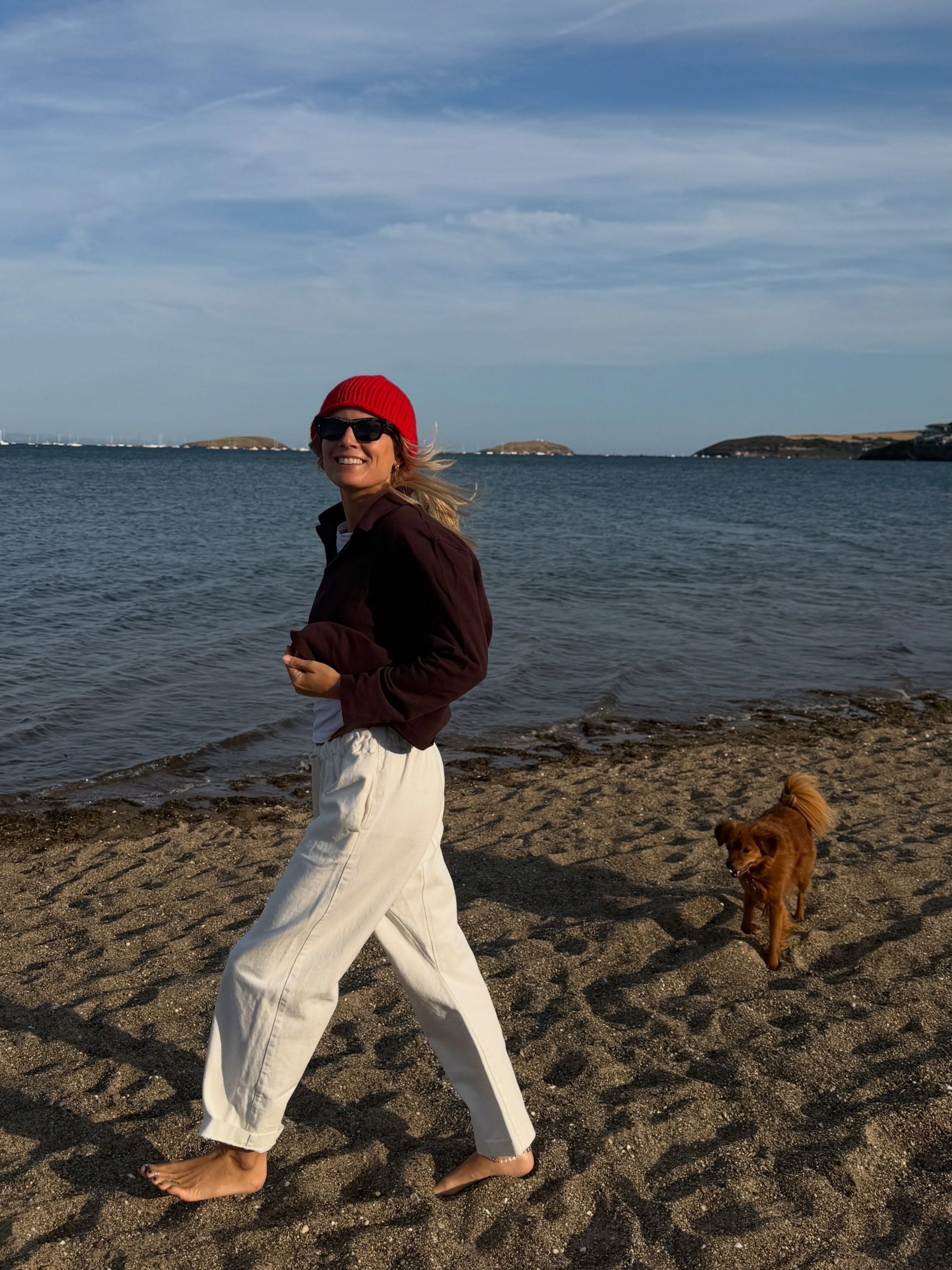 Creator @lucywilliams02 walking on the beach in an autumnal outfit with a black pedicure