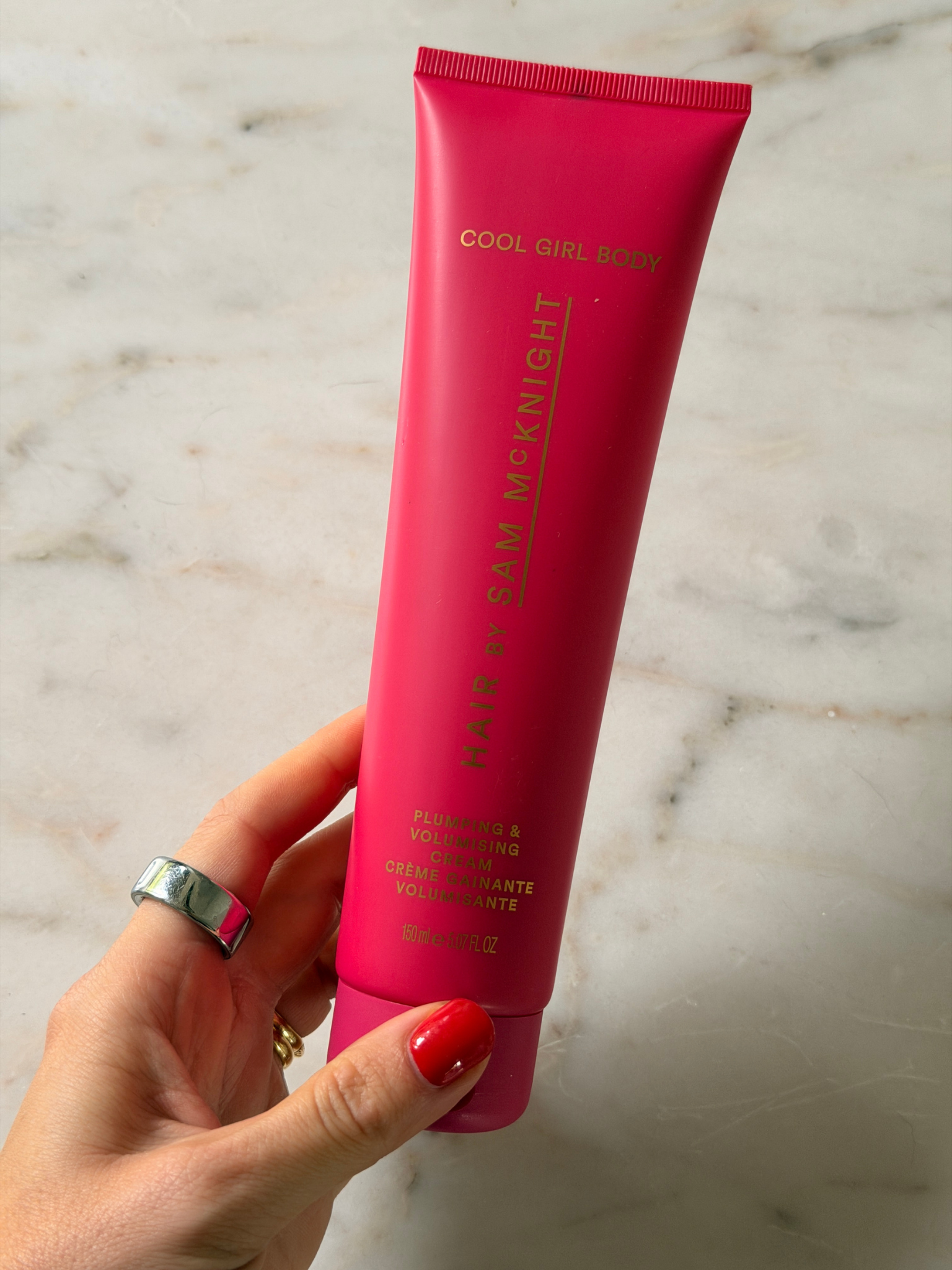 Freelance beauty editor Grace Day holding a tube of the Hair By Sam McKnight Cool Girl Body Plumping & Volumising Cream