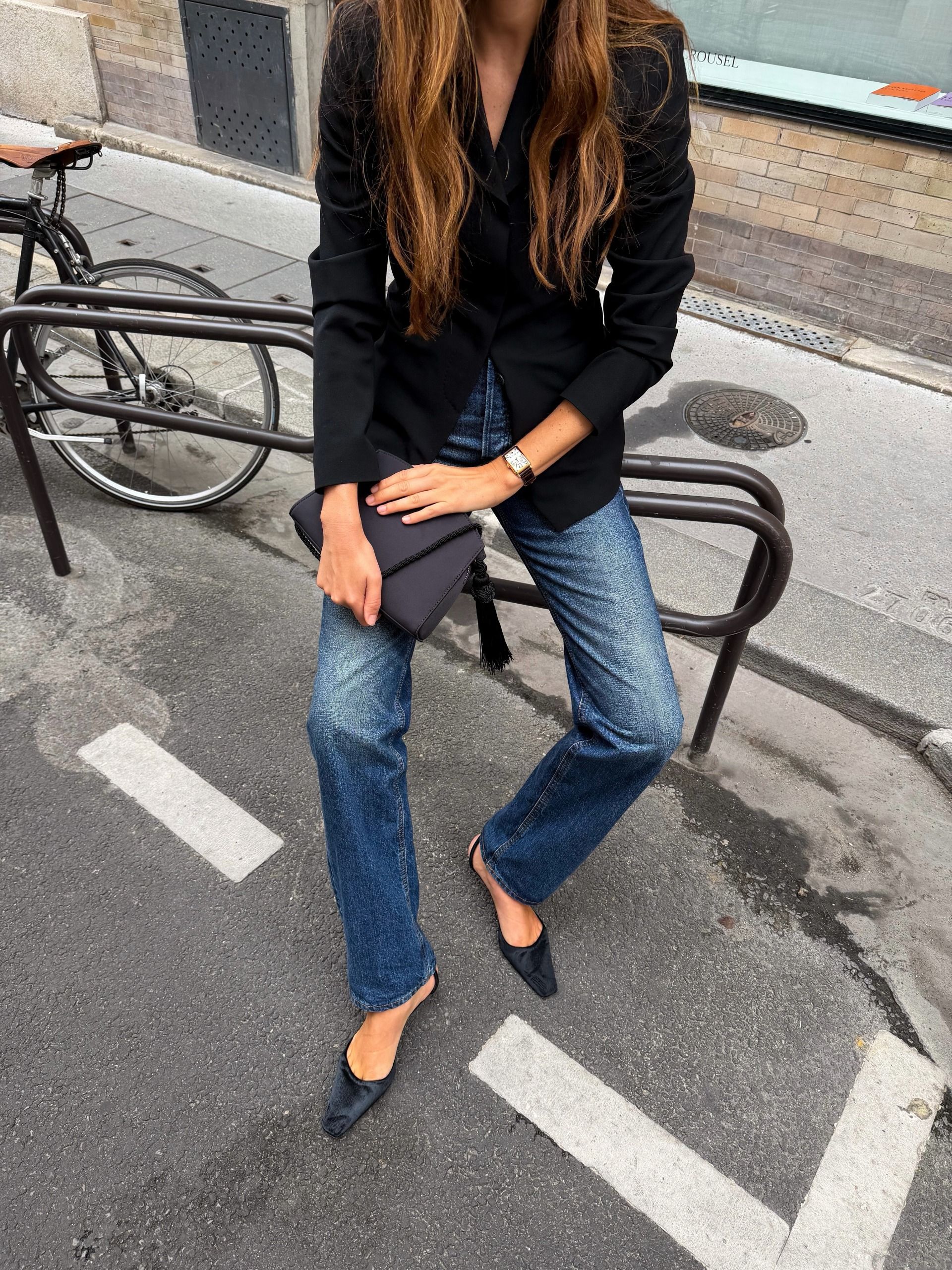 Woman in jeans, a blazer, satin bag, and satin shoes