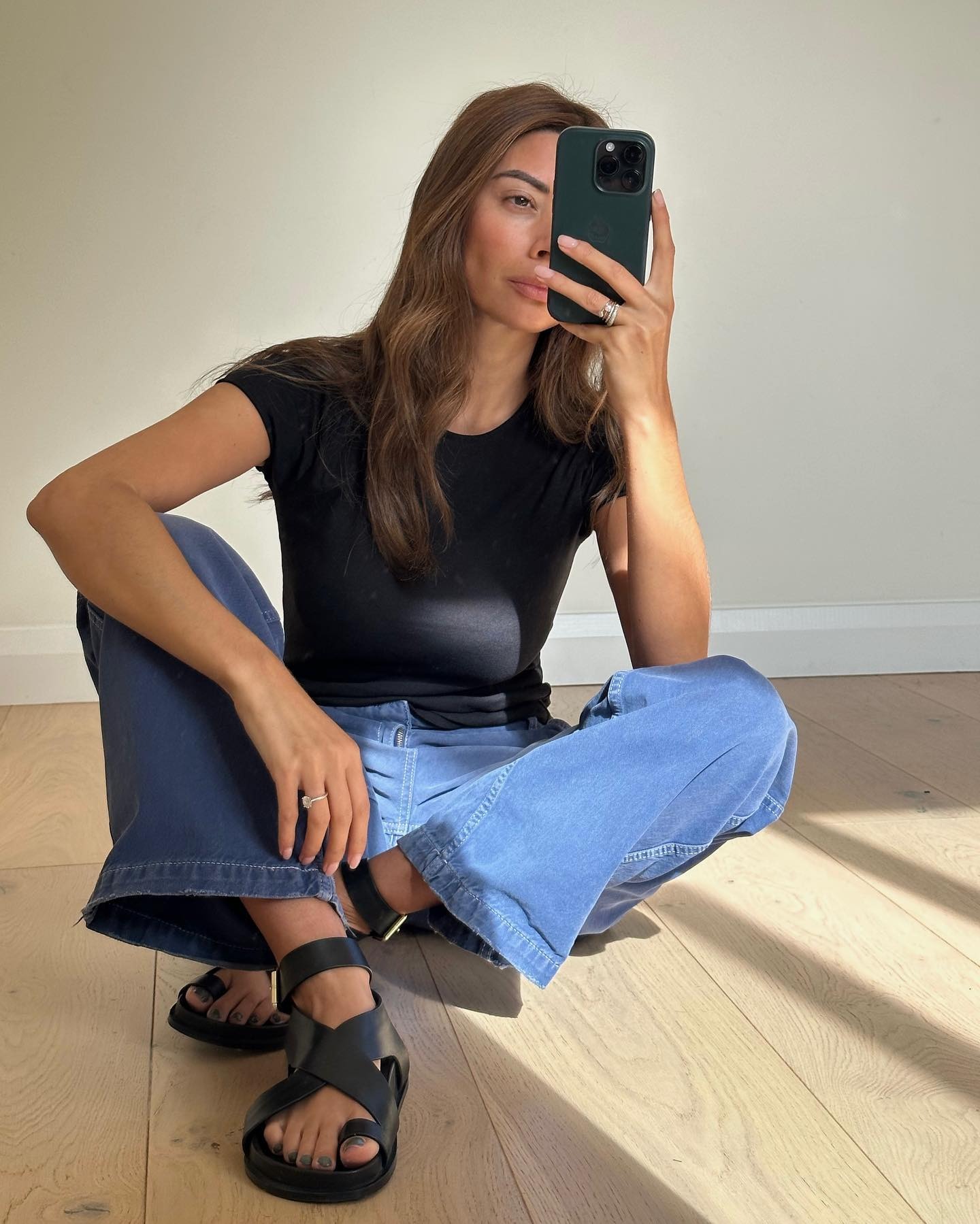 Creator @smythsisters taking a mirror selfie wearing black sandals with a green pedicure
