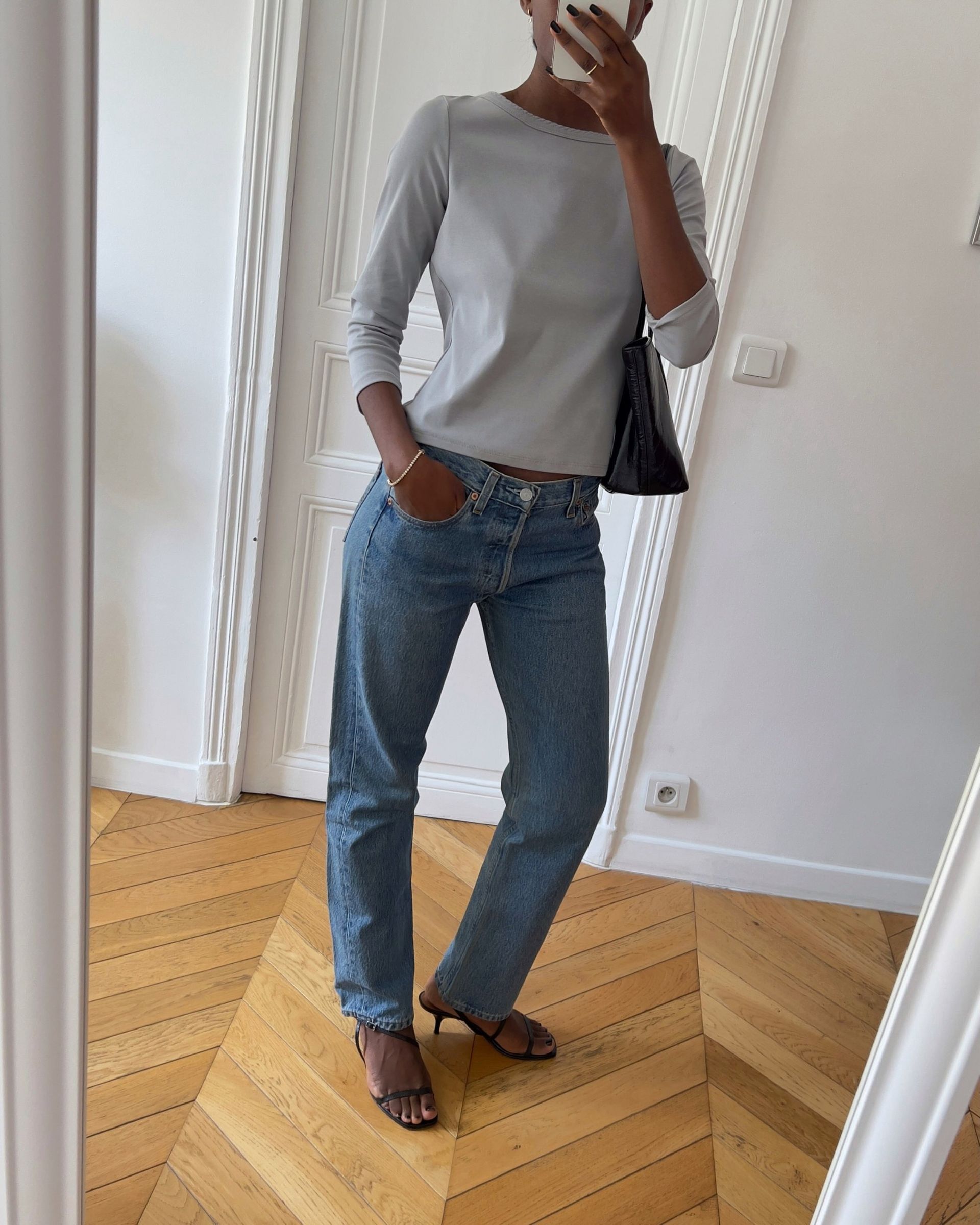 Influencer wearing a 3/4-sleeve gray tee with jeans and strappy heels