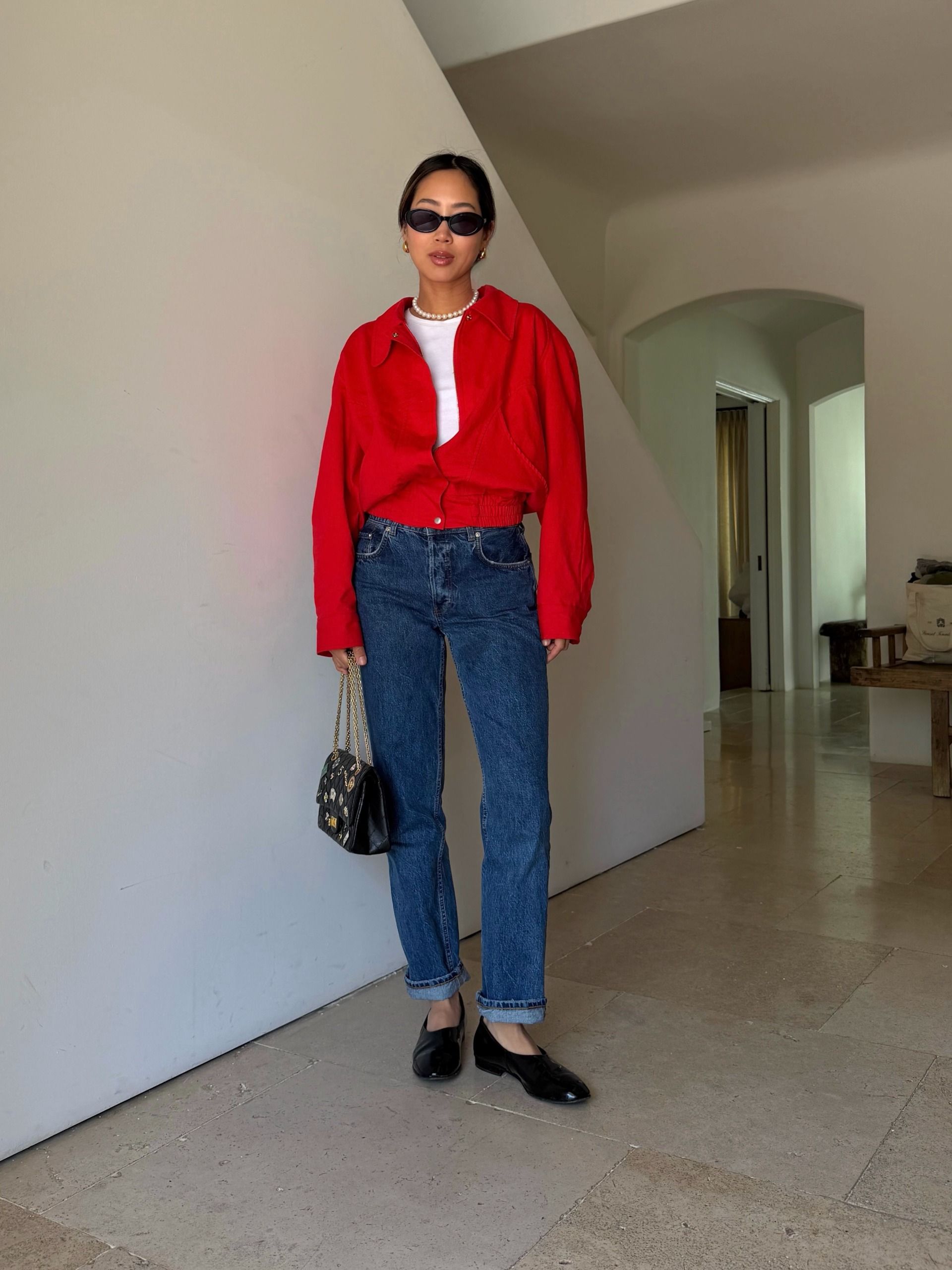 Influencer wearing a red button-down over a white tee with jeans and high-vamp black flats
