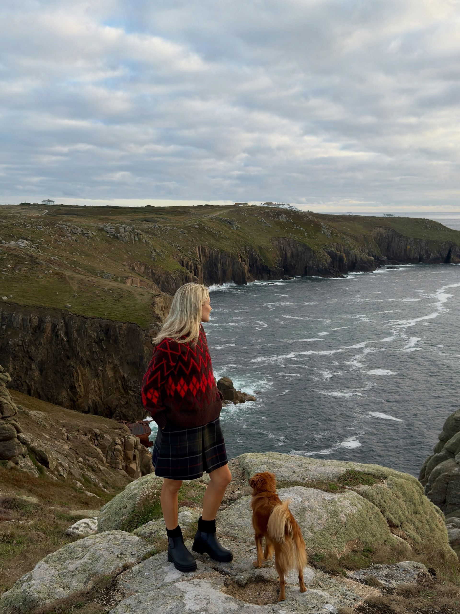 Influencer Lucy Williams wearing an argyl jumper, tartan shorts and ankle boots.