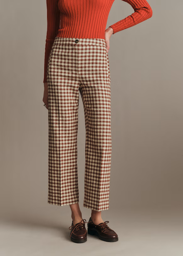 A model wearing brown gingham trousers with loafers.