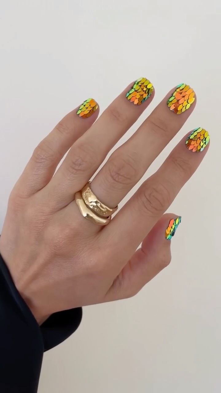 Layered sequin nail art with a holographic effect that resembles dragon scales