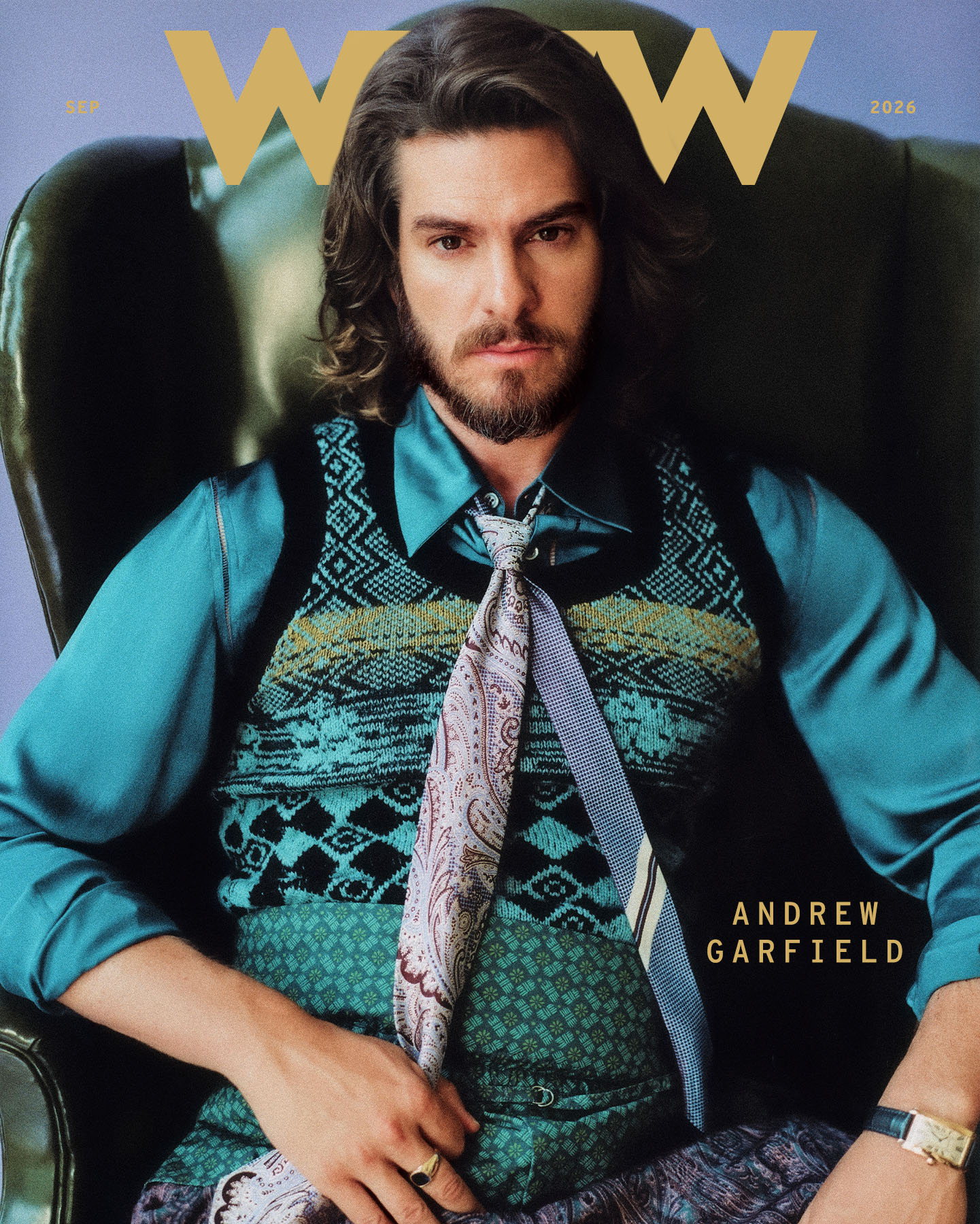 Andrew Garfield for Who What Wear's September cover wearing a blue zipper-accented button-down with a patterned sweater vest, tie, and pants.