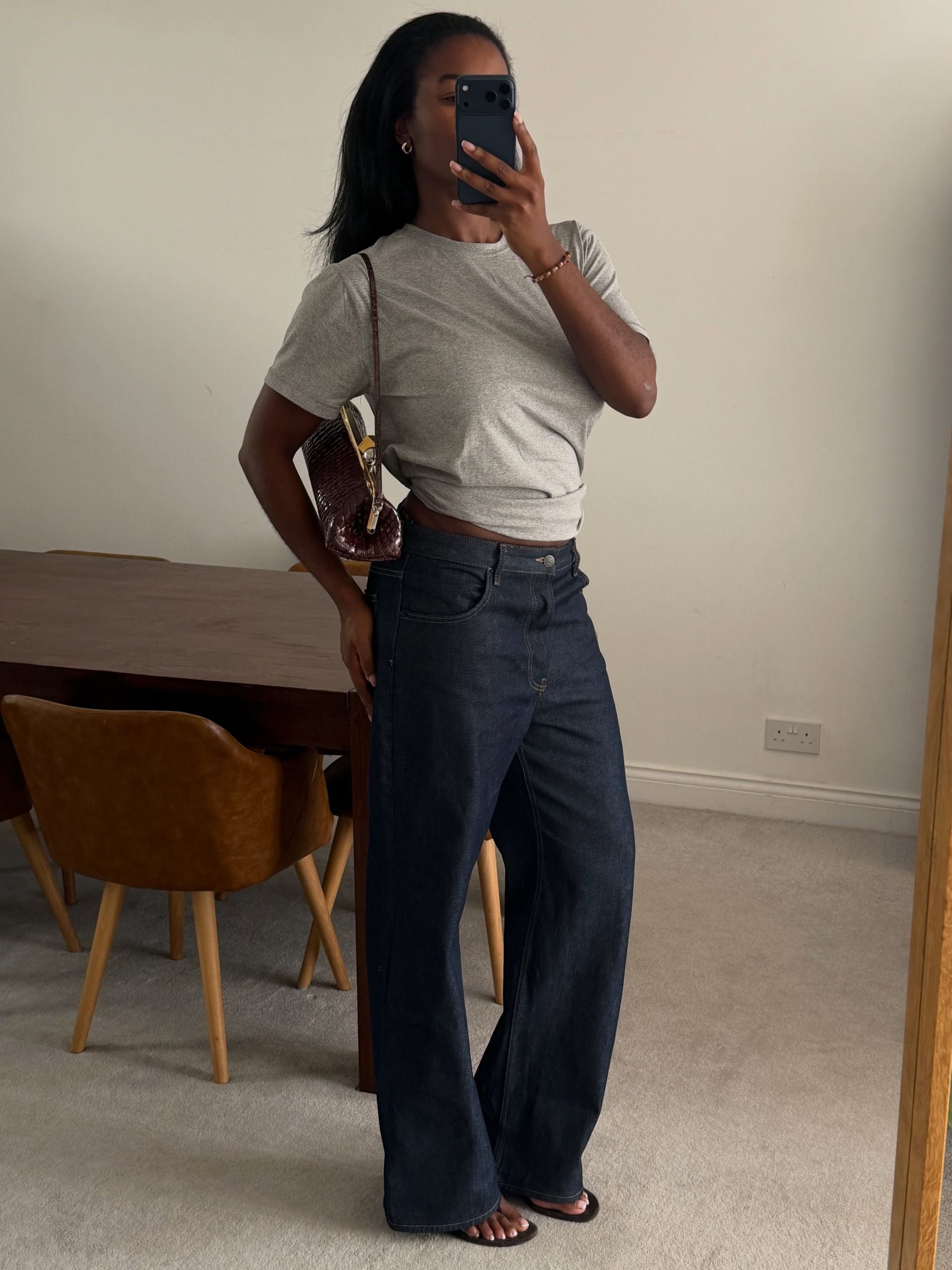 Woman in a gray tee and dark wash jeans