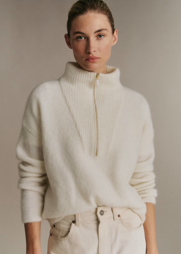 A model wears an ivory Sezane half-zip jumper.