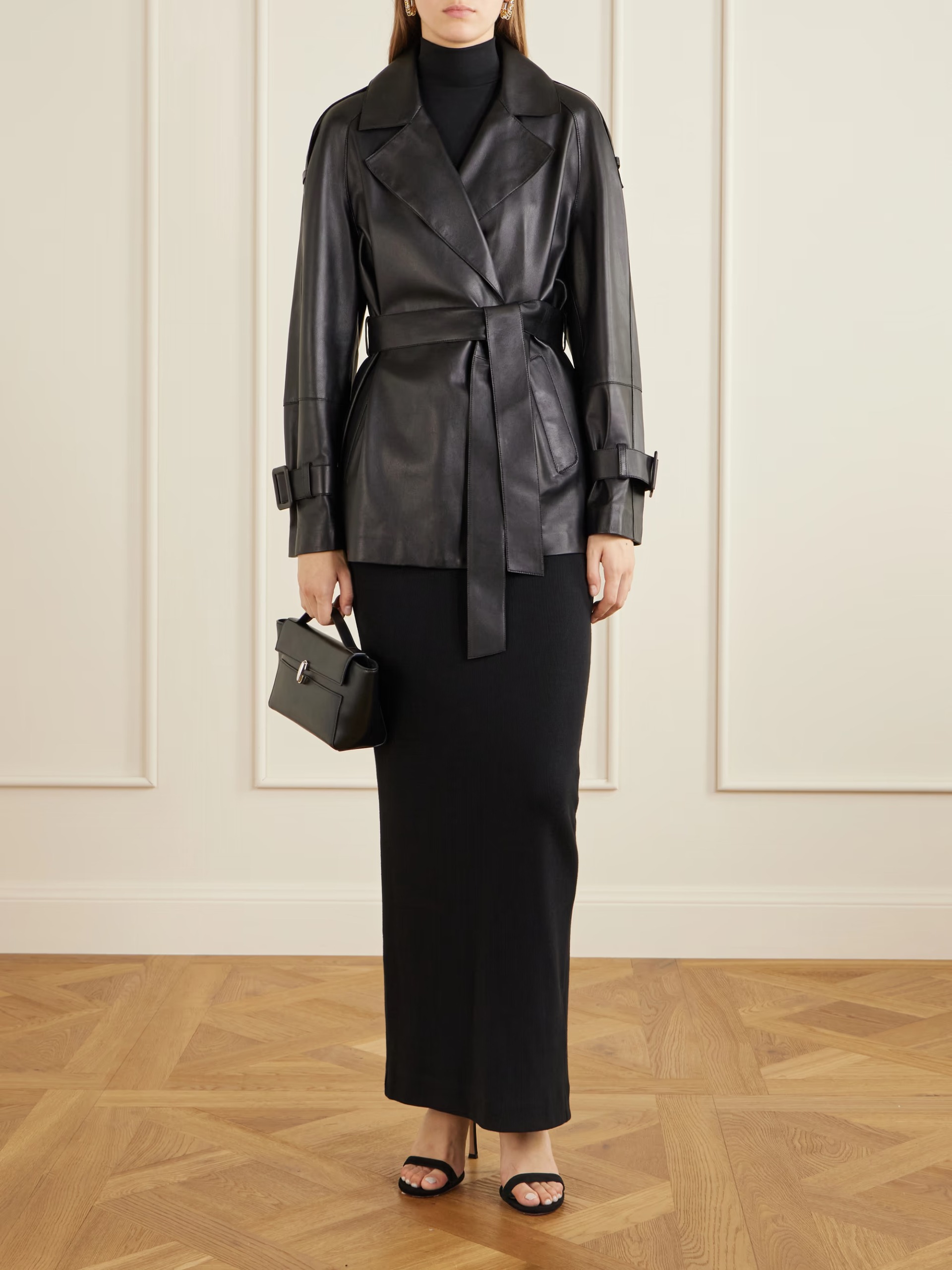 An image of a model wearing the Nour Hammour belted leather jacket with a black maxi skirt and black heels