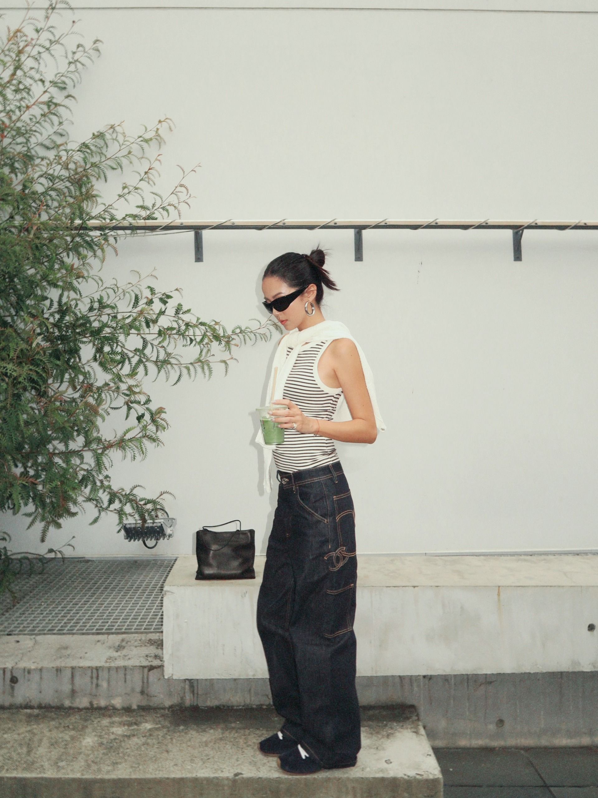 Influencer YOYO CAO wearing indigo jeans and navy suede trainers.