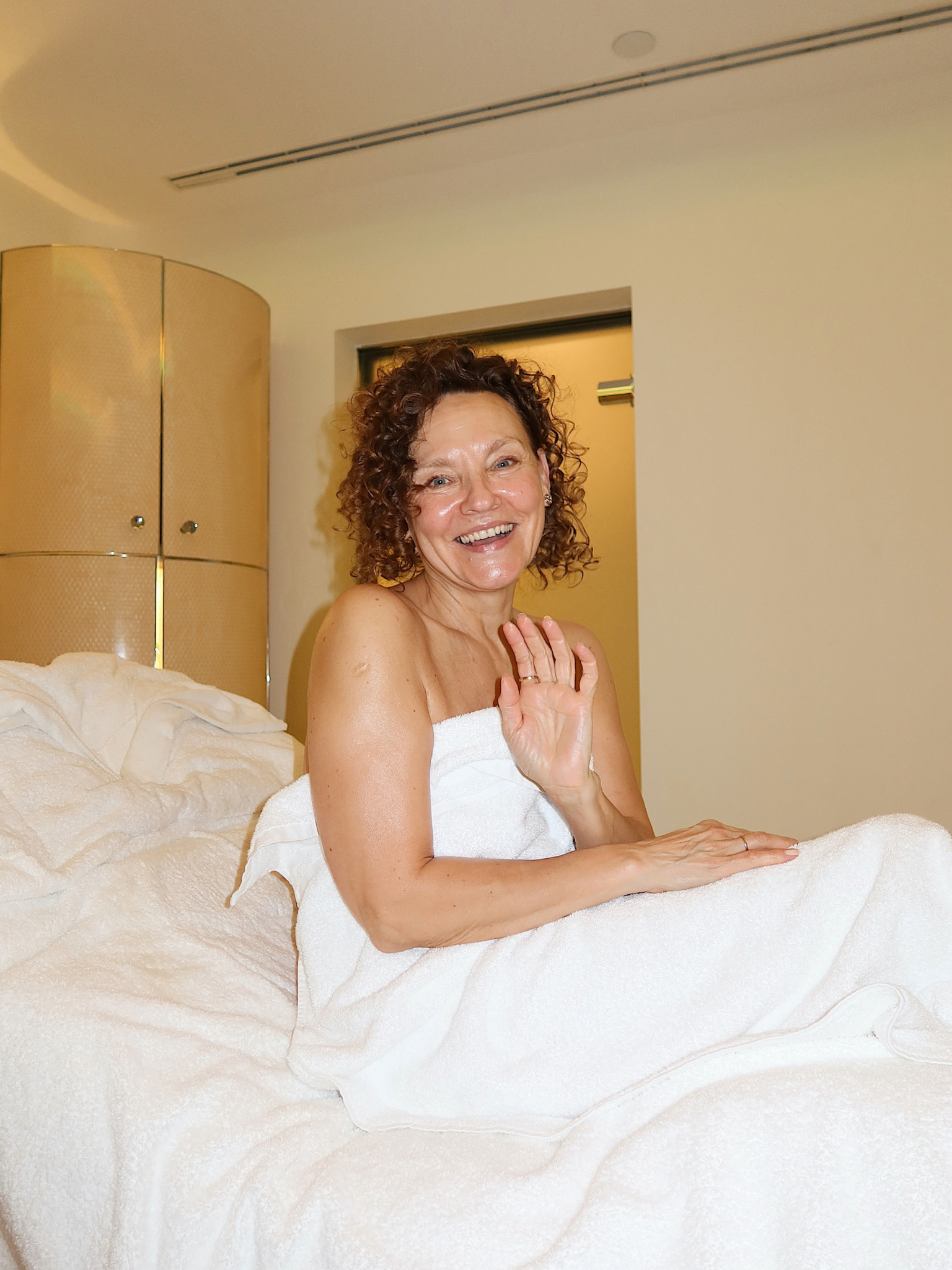 A woman sitting on a spa bed and smiling