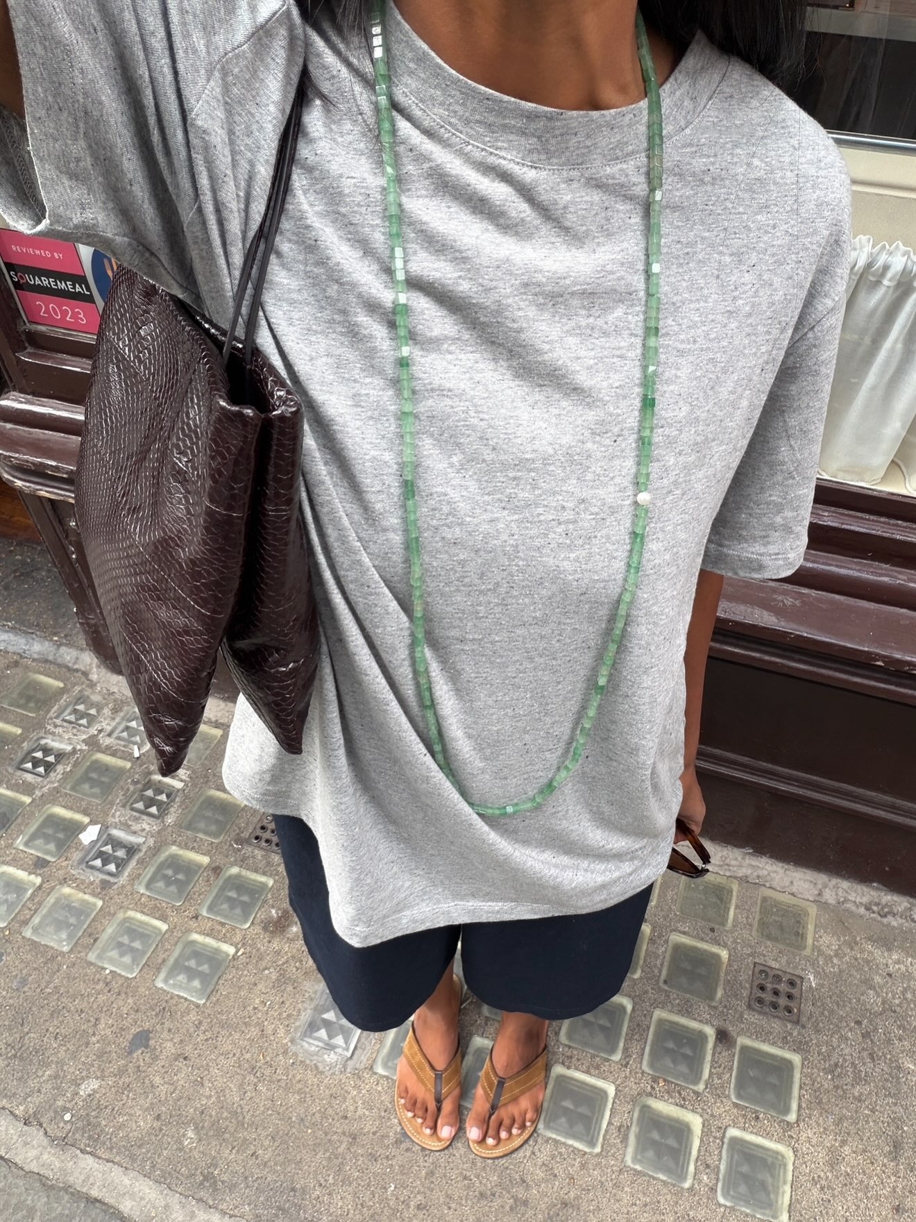 Creator @monikh taking a selfie in a transitional outfit with a milky pedicure